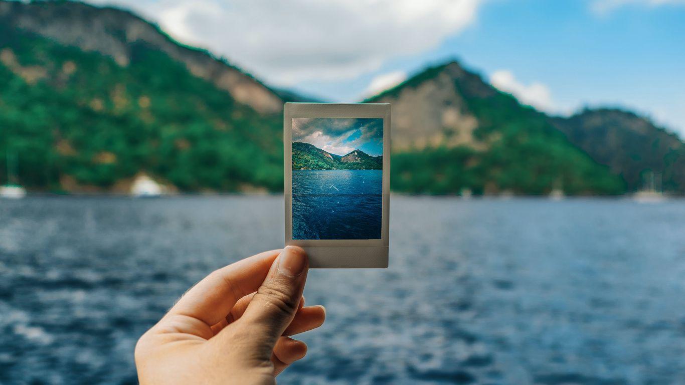 1366x768 Download wallpaper 1366x768 photography, polaroid, hand, mountains