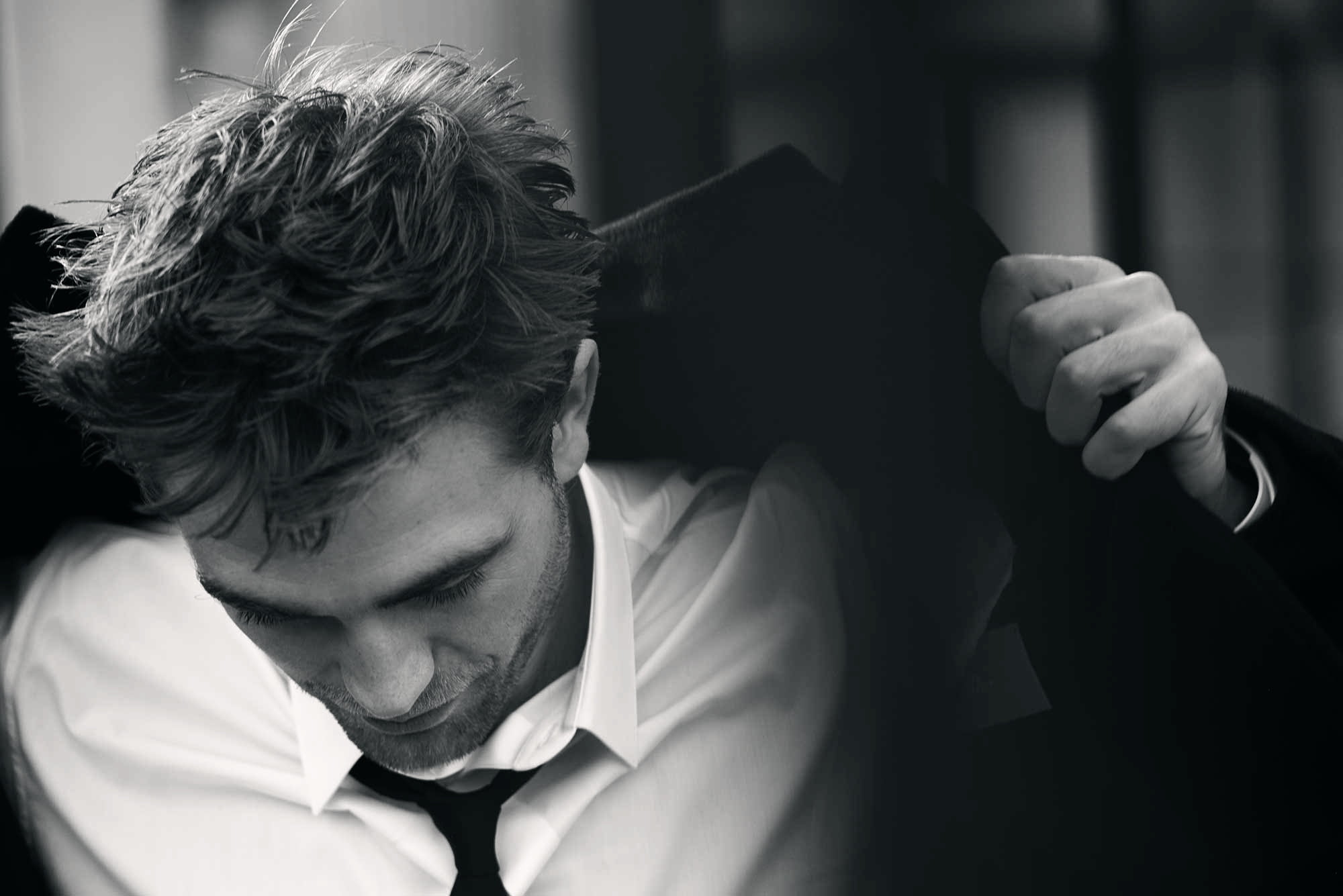 2000x1335 Grayscale photography of a man bow down his head while holding his black coat HD wallpaper