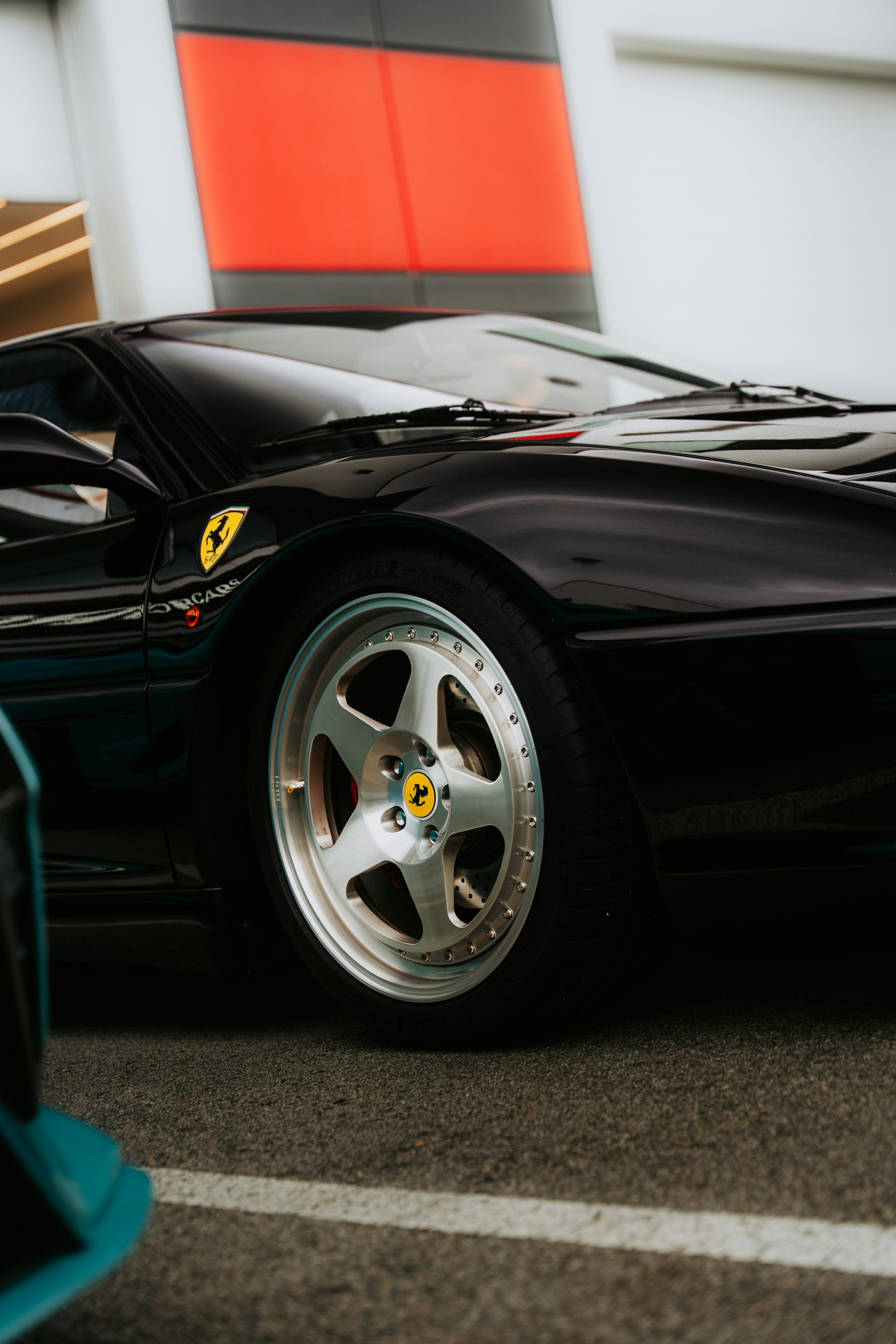 3000x4500 A sleek black ferrari shows off its wheel. photo