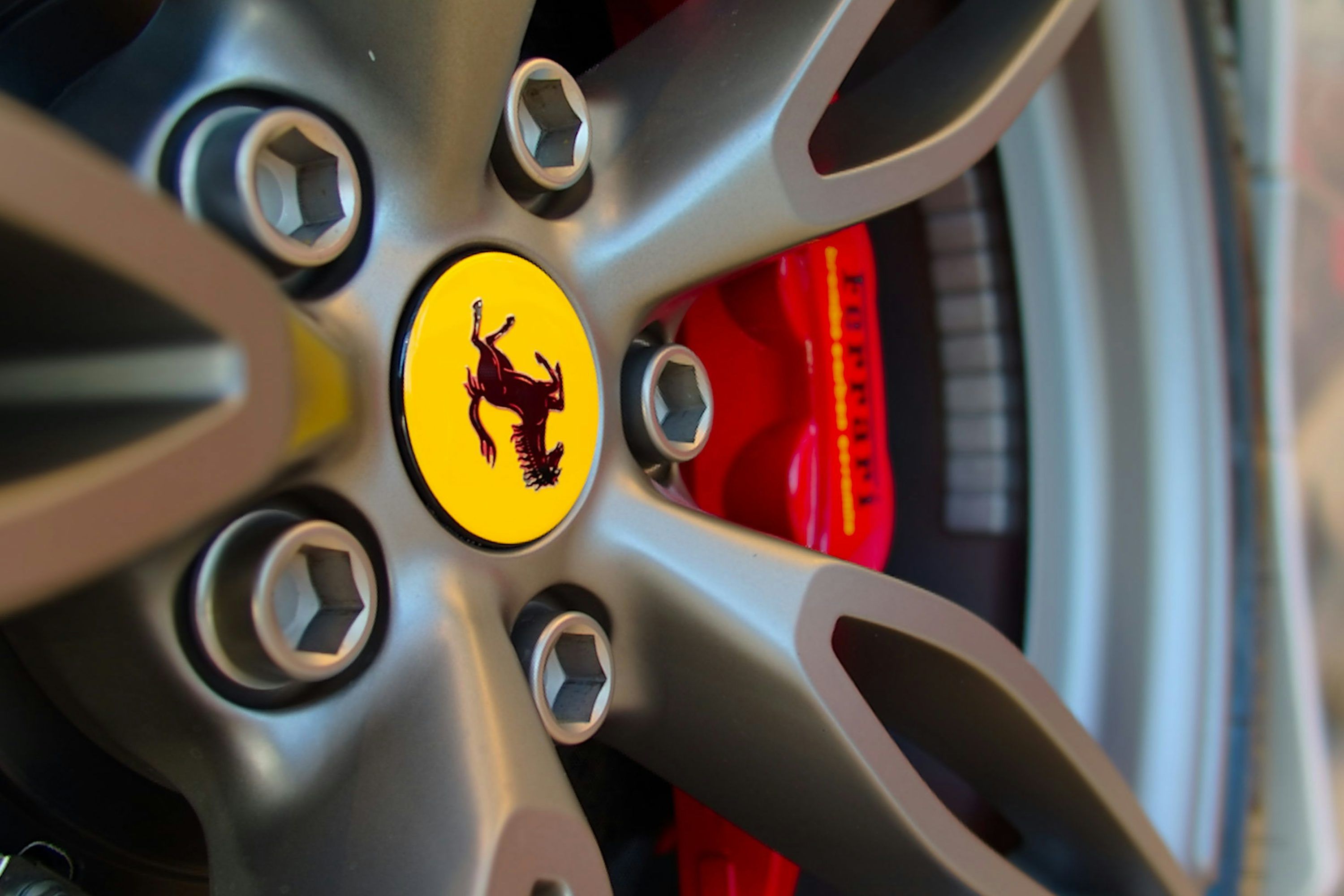 3000x2000 A close up of a wheel with a ferrari logo on it photo