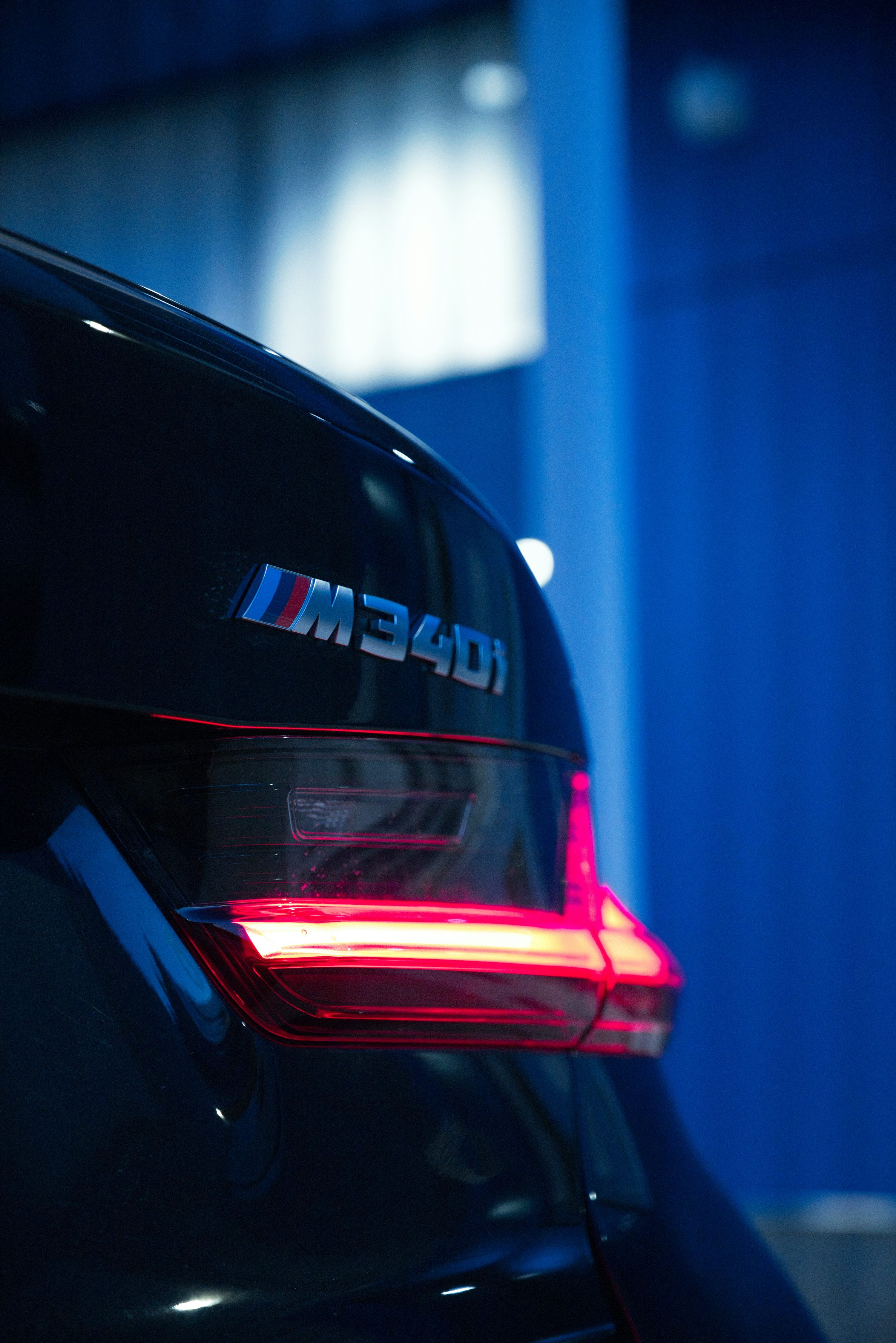 3000x4494 A black bmw's tail light shines brightly. photo