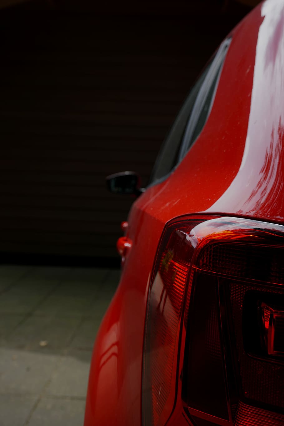 910x1365 HD wallpaper: red vehicle park in room, closeup photography of red car, tail light