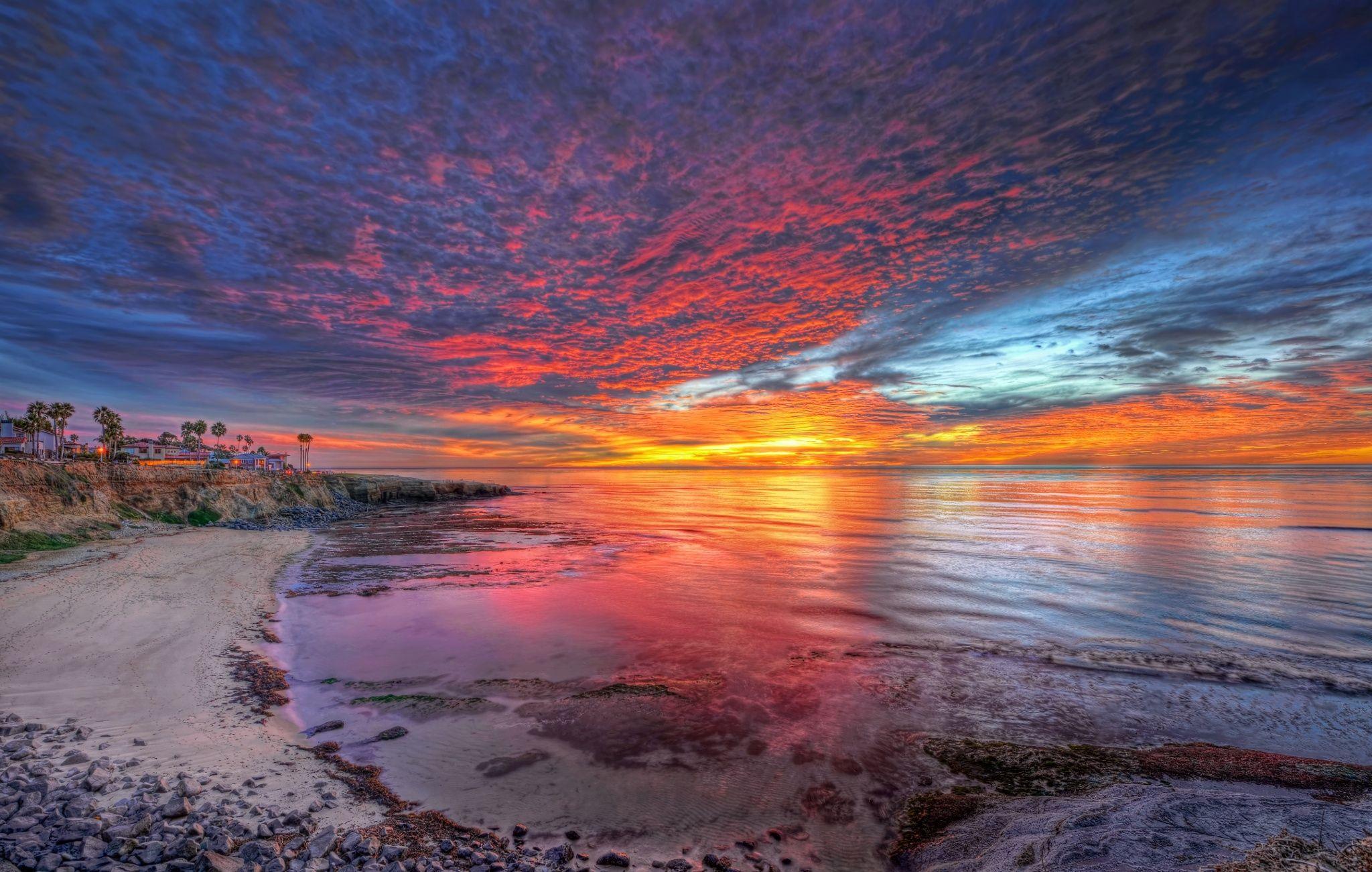 2048x1301 red, orange, sea, rocks, sunset, blue, sky, colors, sand, yellow, beautiful, houses, lovely, clouds, cove, California, beach wallpaper