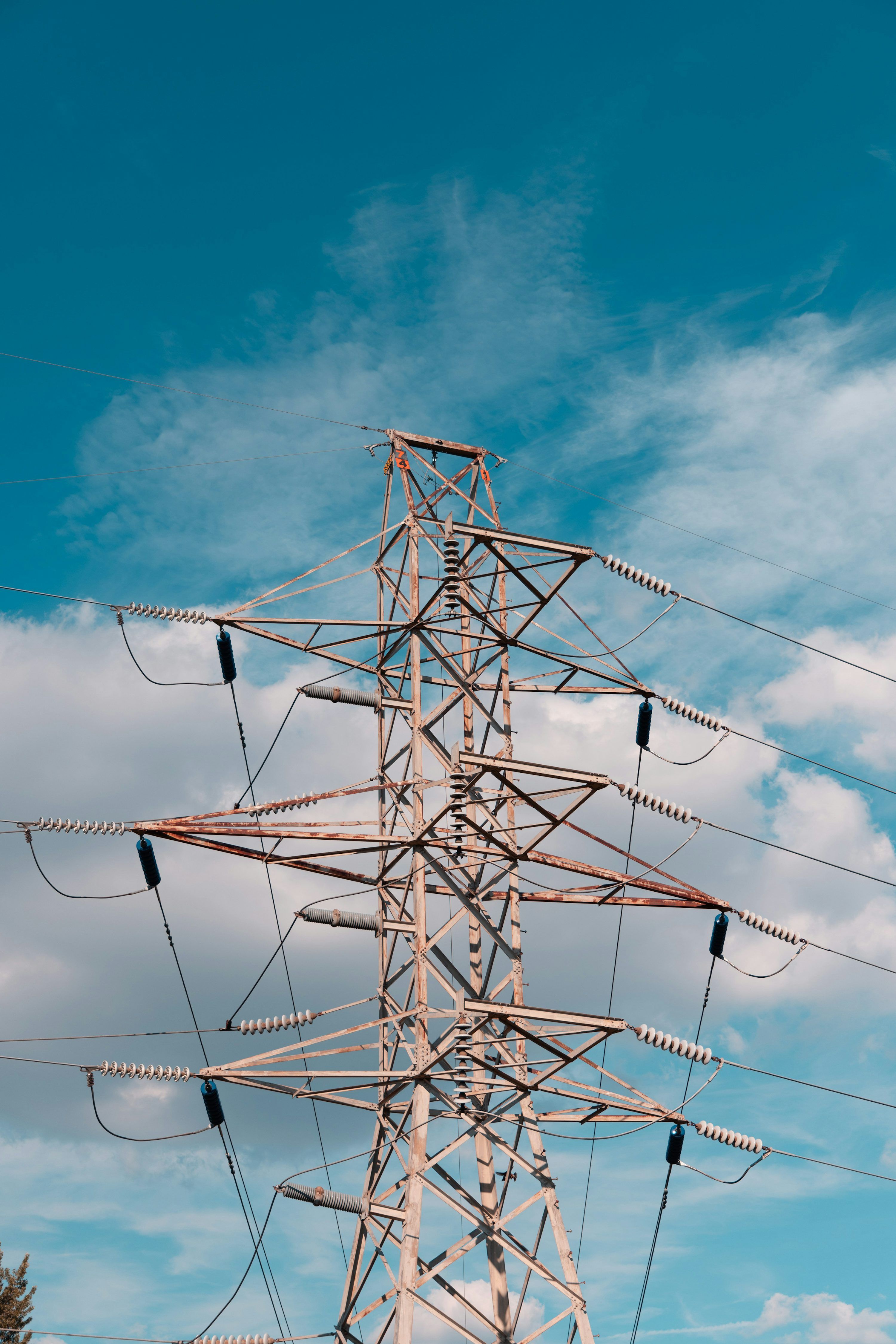 3000x4498 A high voltage power line with a blue sky in the background photo