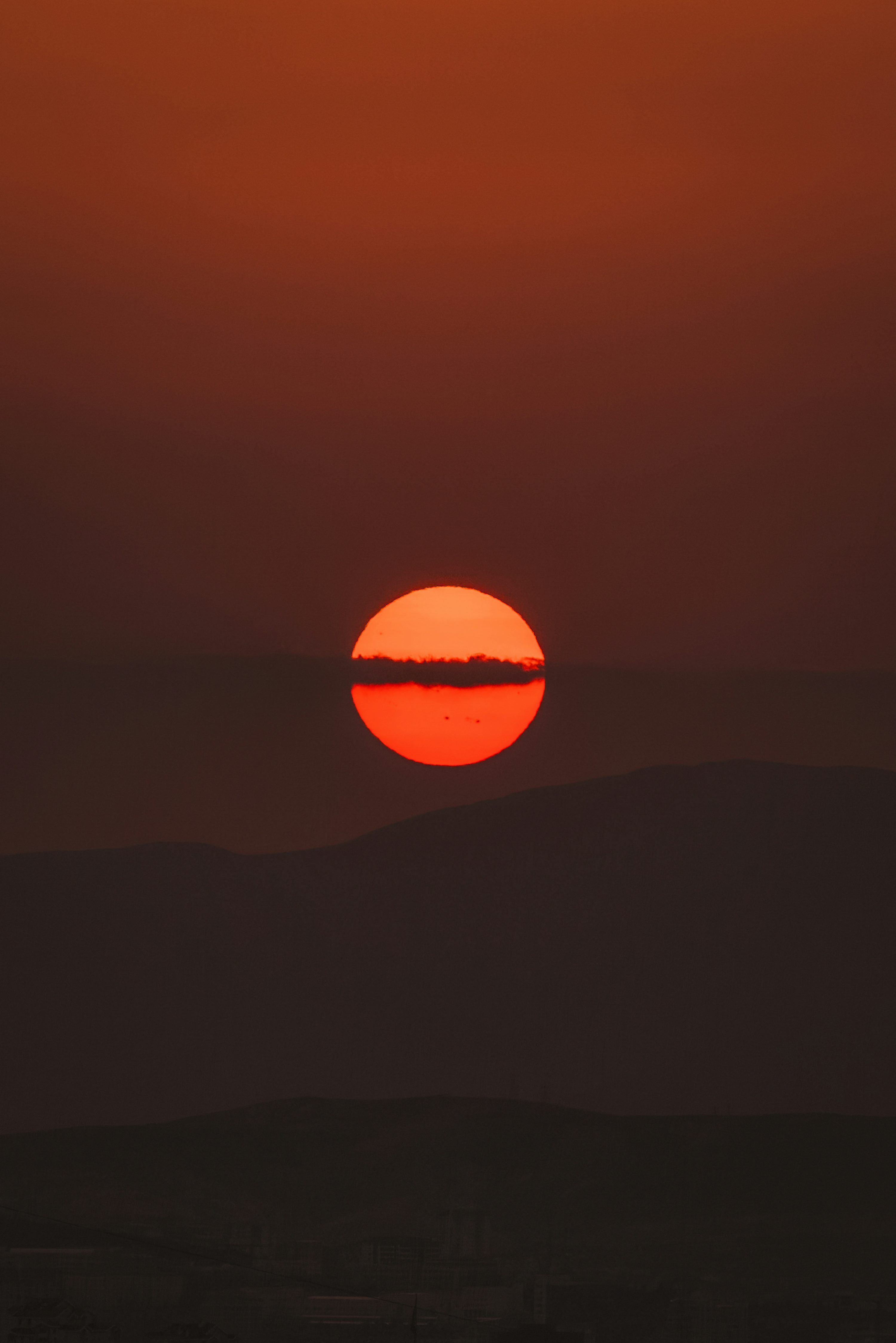 3000x4495 The sun is setting over the horizon of a large body of water photo