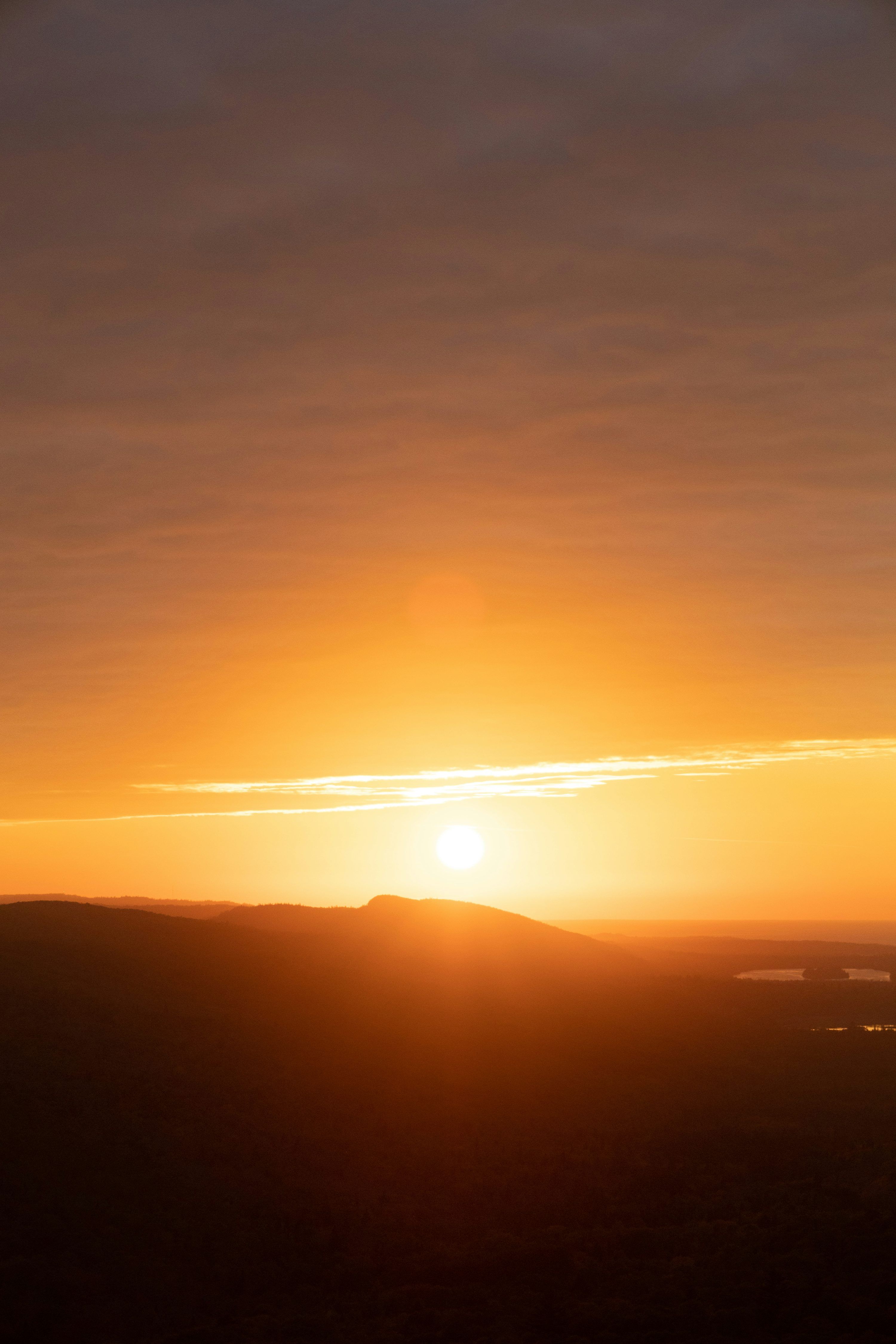 3000x4500 The sun is setting over the horizon of a field photo