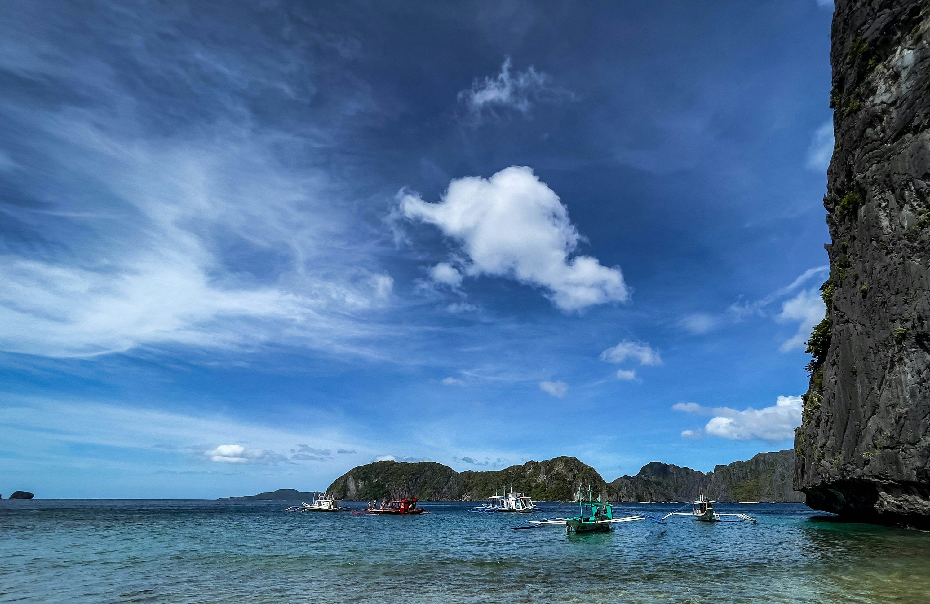 3000x1950 Boats float on calm waters under a bright blue sky. photo