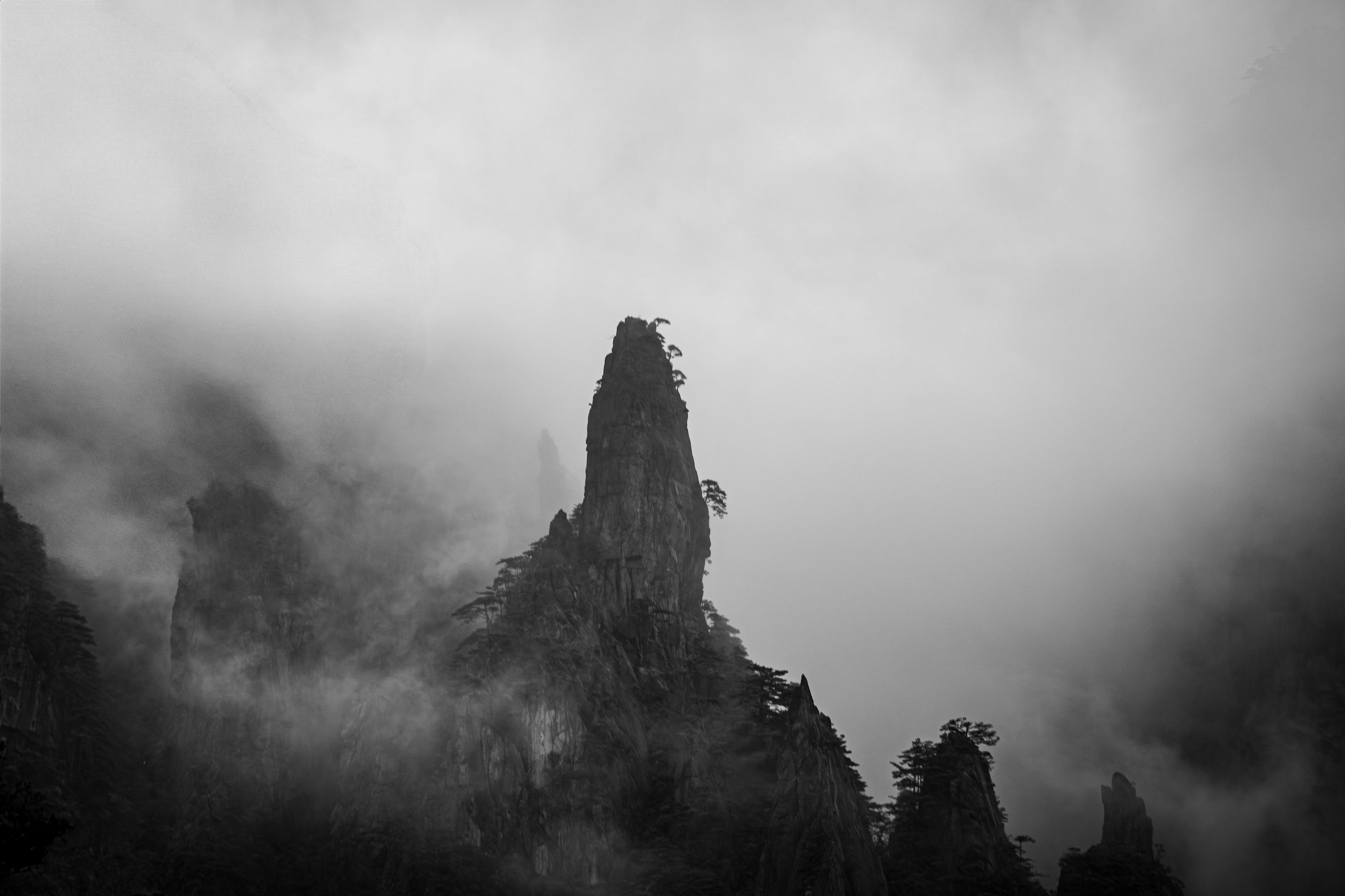 3000x2000 A black and white photo of a mountain in the fog photo