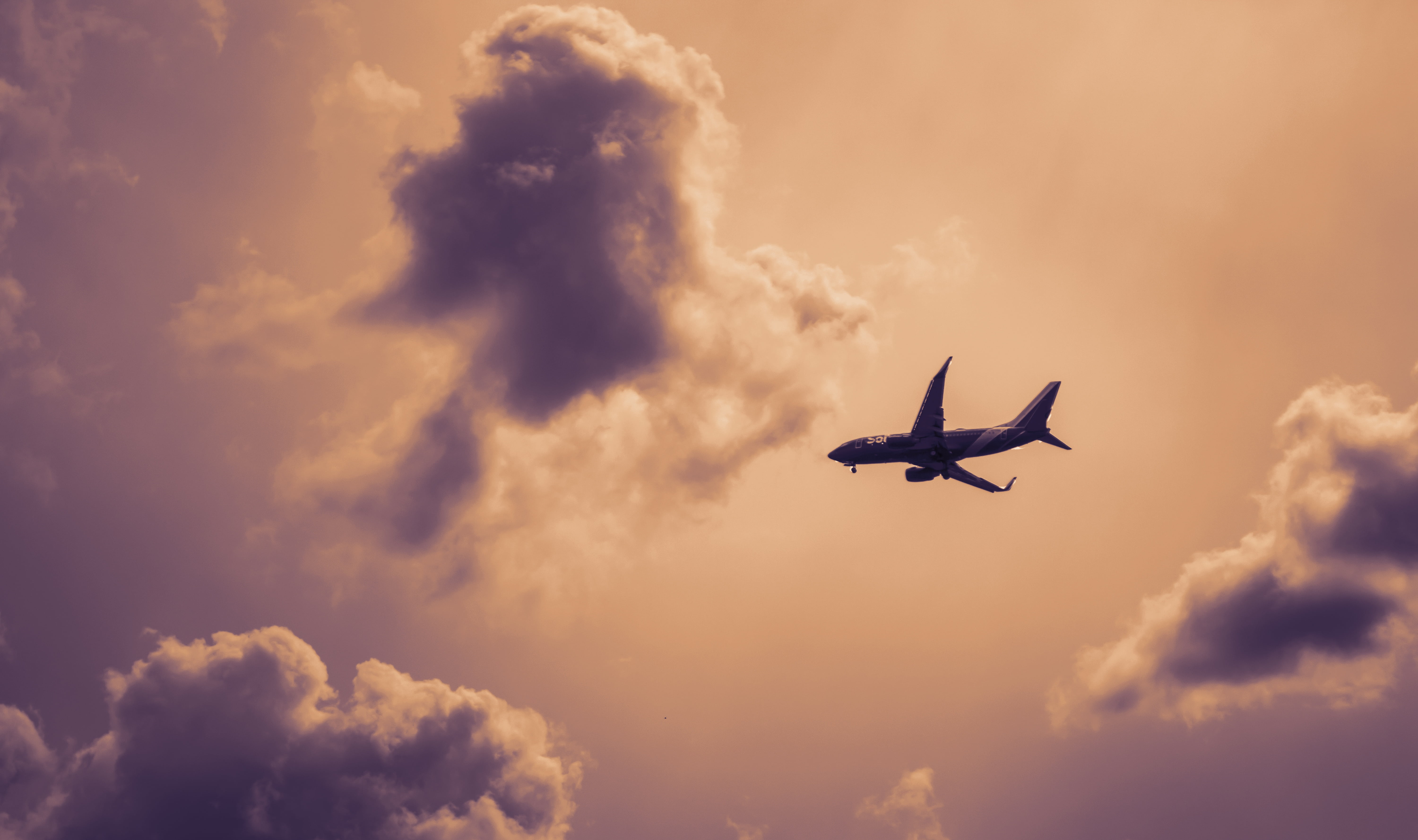 6000x3556 Royalty Free Photo: Silhouette Of A Plane Flying Above The Sky