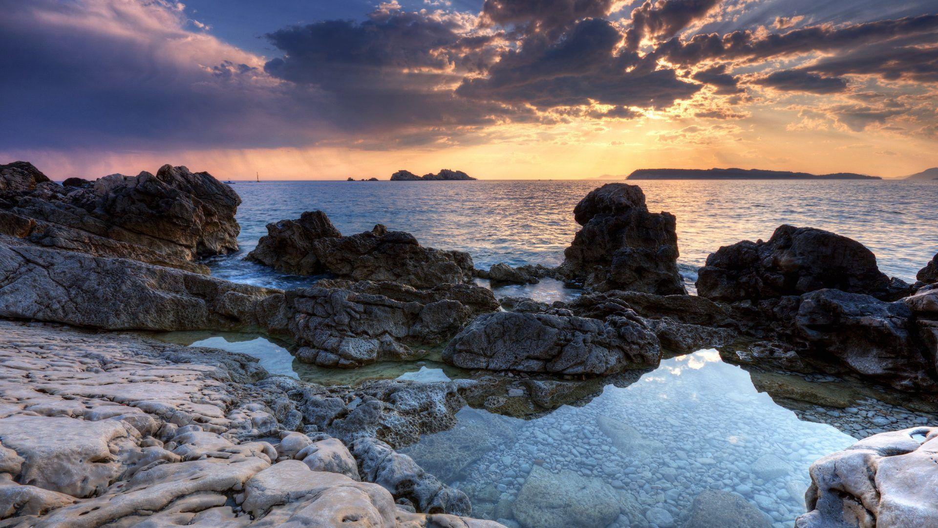 1920x1080 Moments Bliss Rocky Sunset Cam Colors Water Serene Nature Beaches Beautiful Reflection Clouds Calm Shore Beach HD Wallpaper For Desktop