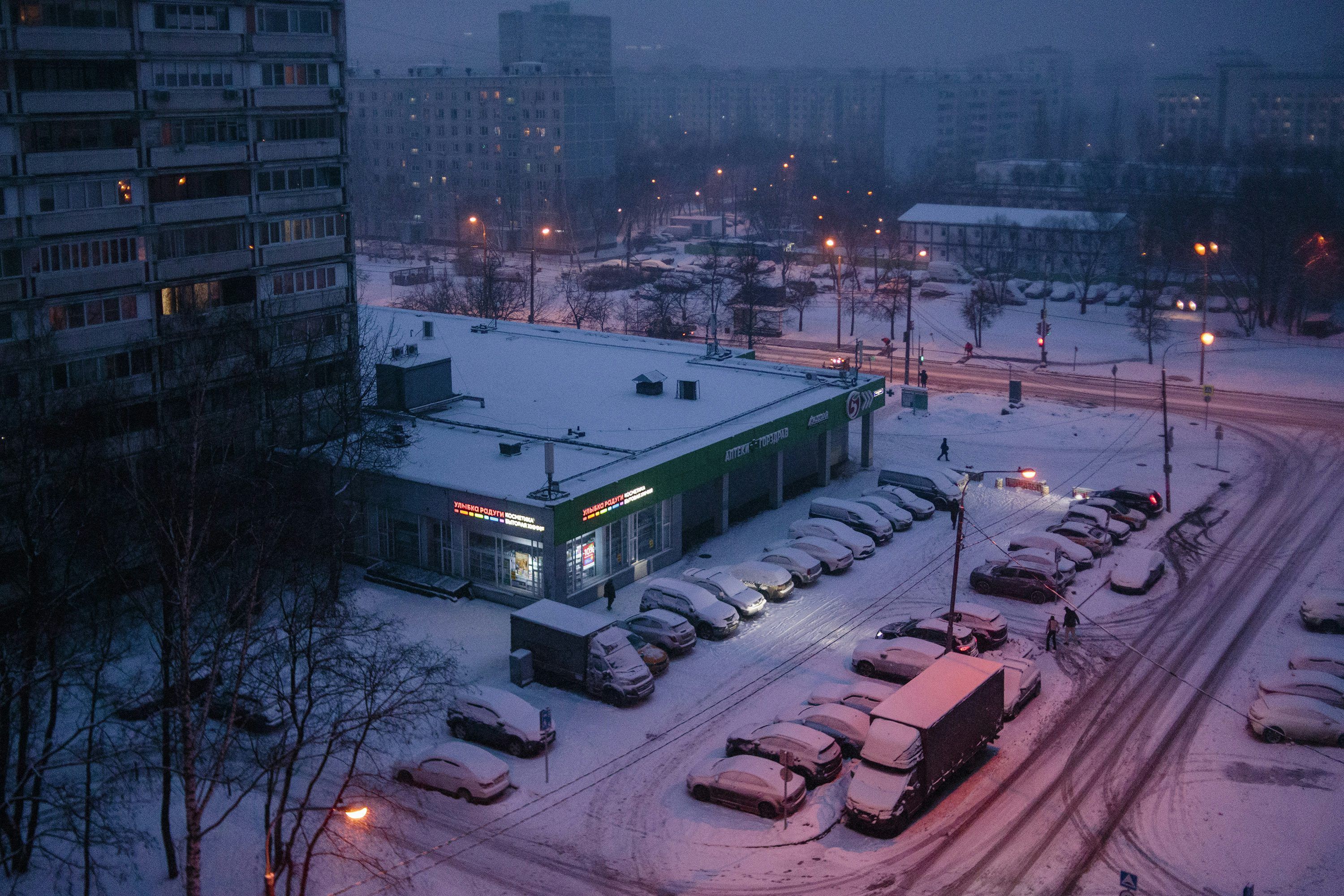 3000x2000 A parking lot covered in snow next to tall buildings photo