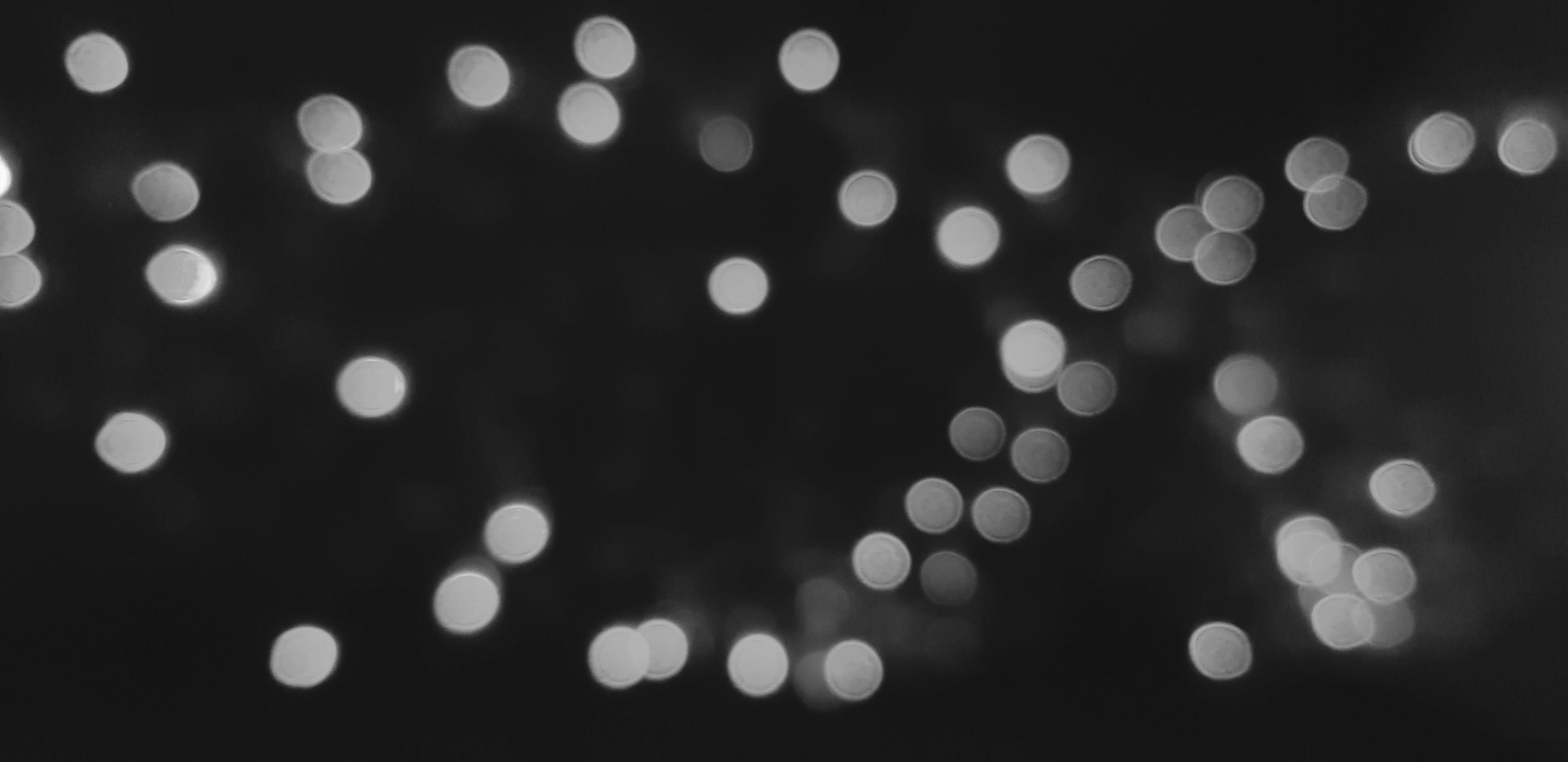 4032x1960 Blurred gray or grey Bokeh of light on dark or black background in monochrome style. Lighting blurry wallpaper. Festival or Celebration and Art of abstract concept