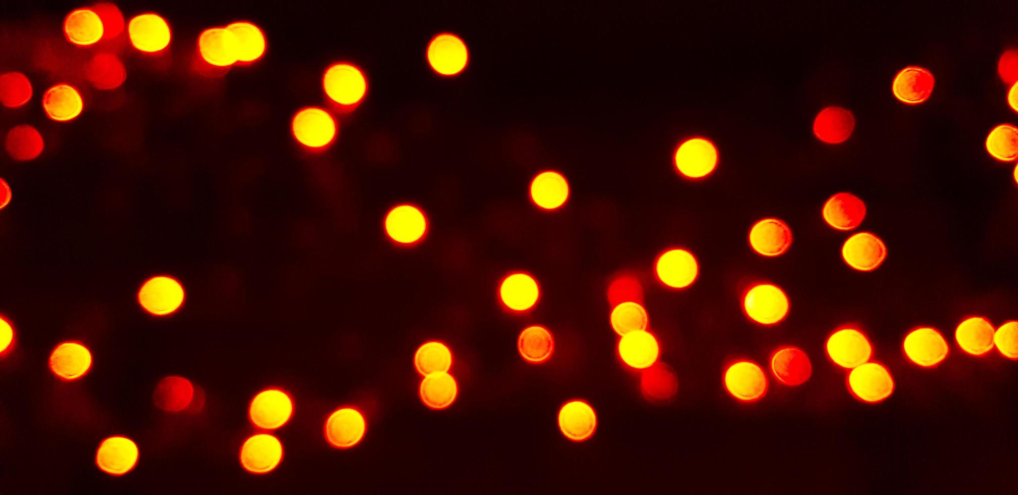 2016x980 Blurred yellow Bokeh of light on dark or black background. Lighting blurry wallpaper. Festival and Celebration concept