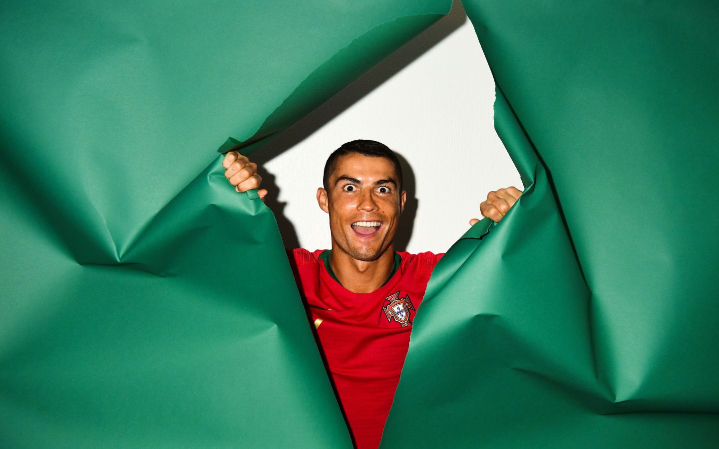 1440x900 Funny face of football player Cristiano Ronaldo on a green background Desktop wallpaper 1440x900
