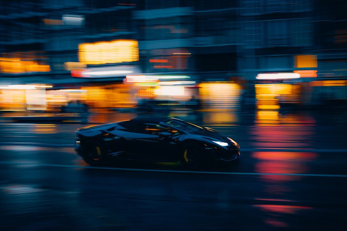 1125x750 Speeding Luxury Car at Night on City Street · Free