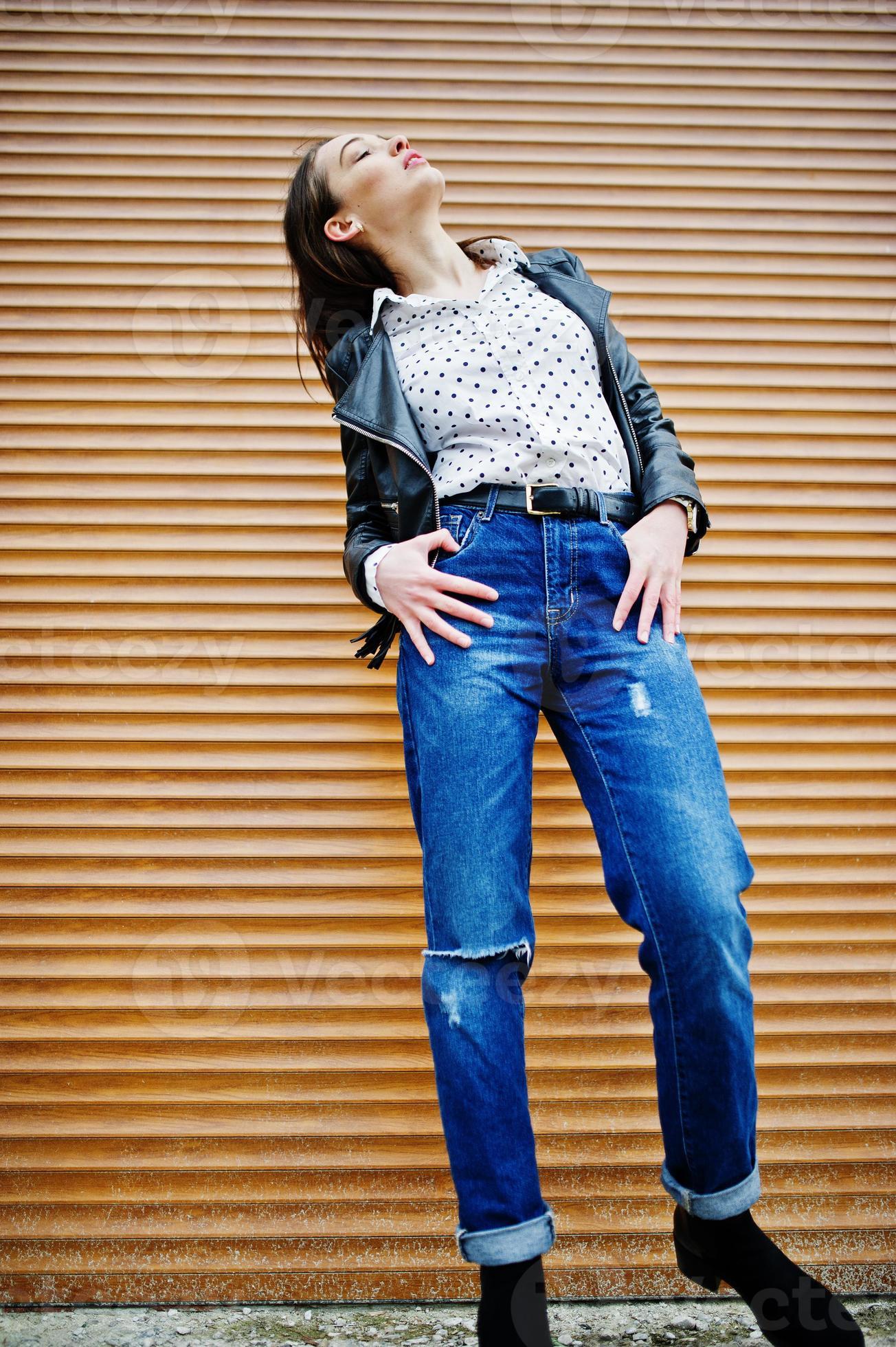 1304x1960 Full length portrait of stylish young girl wear on leather jacket and ripped jeans background shutter texture. Street fashion model style