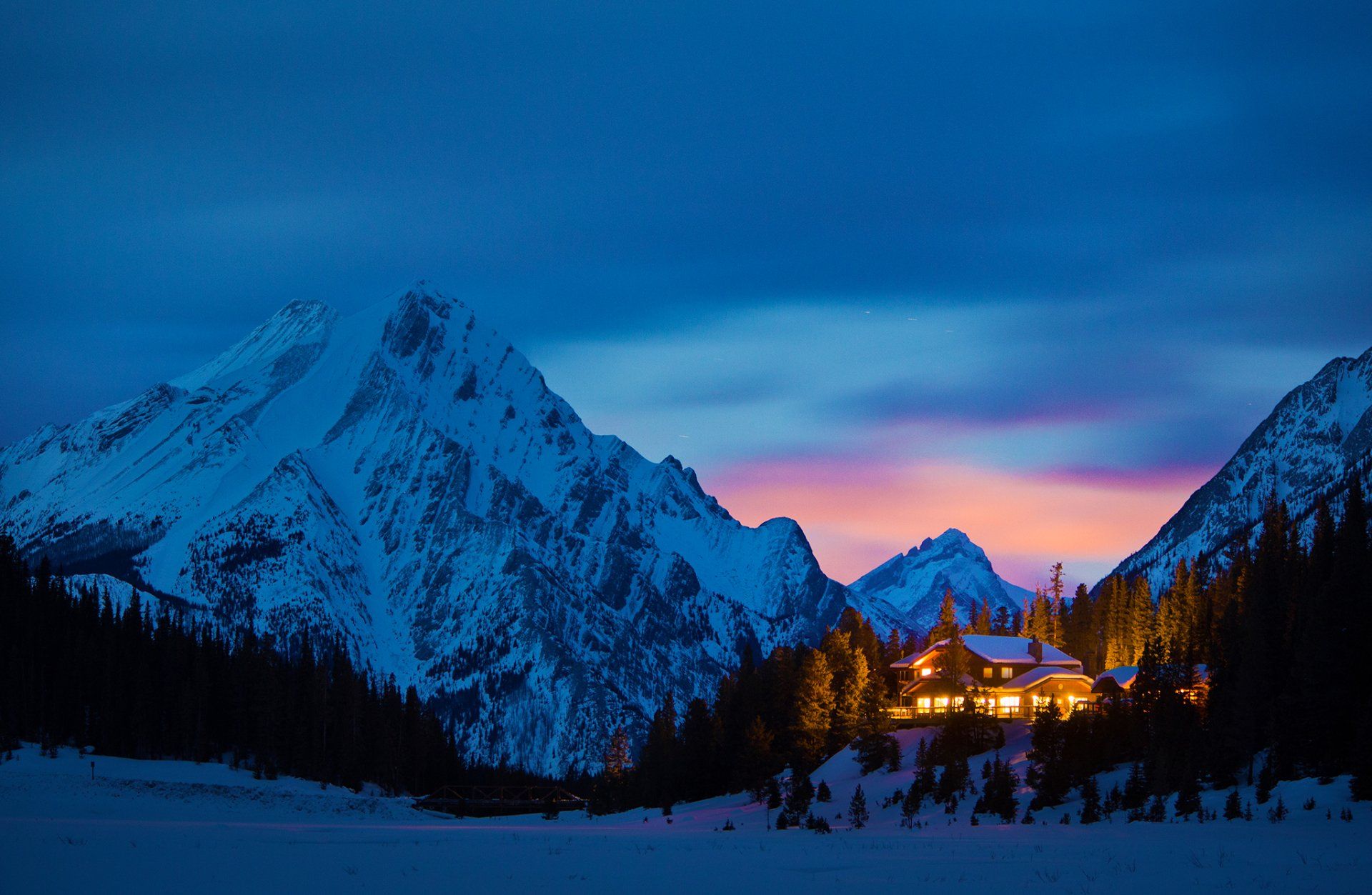 1920x1253 Winter Night Glow: Snowy Mountain Cabin in Evening Light
