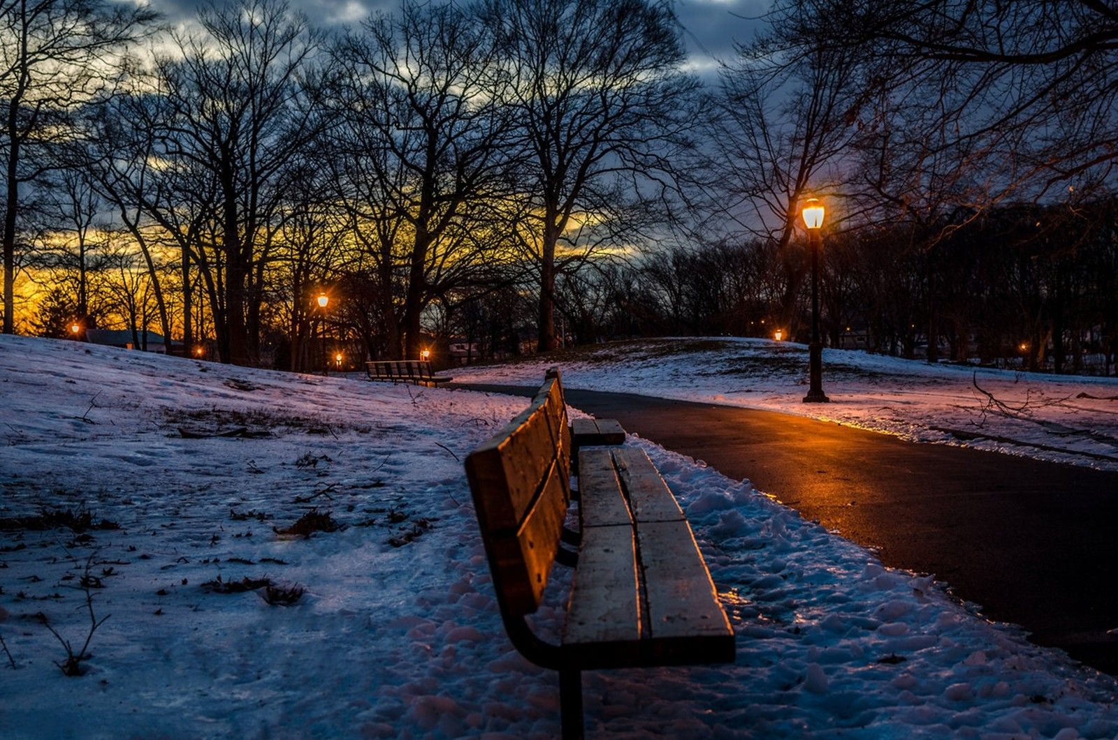 1600x1060 Winter Night Serenity: Snowy Park Bench Under Soft Lamp Light