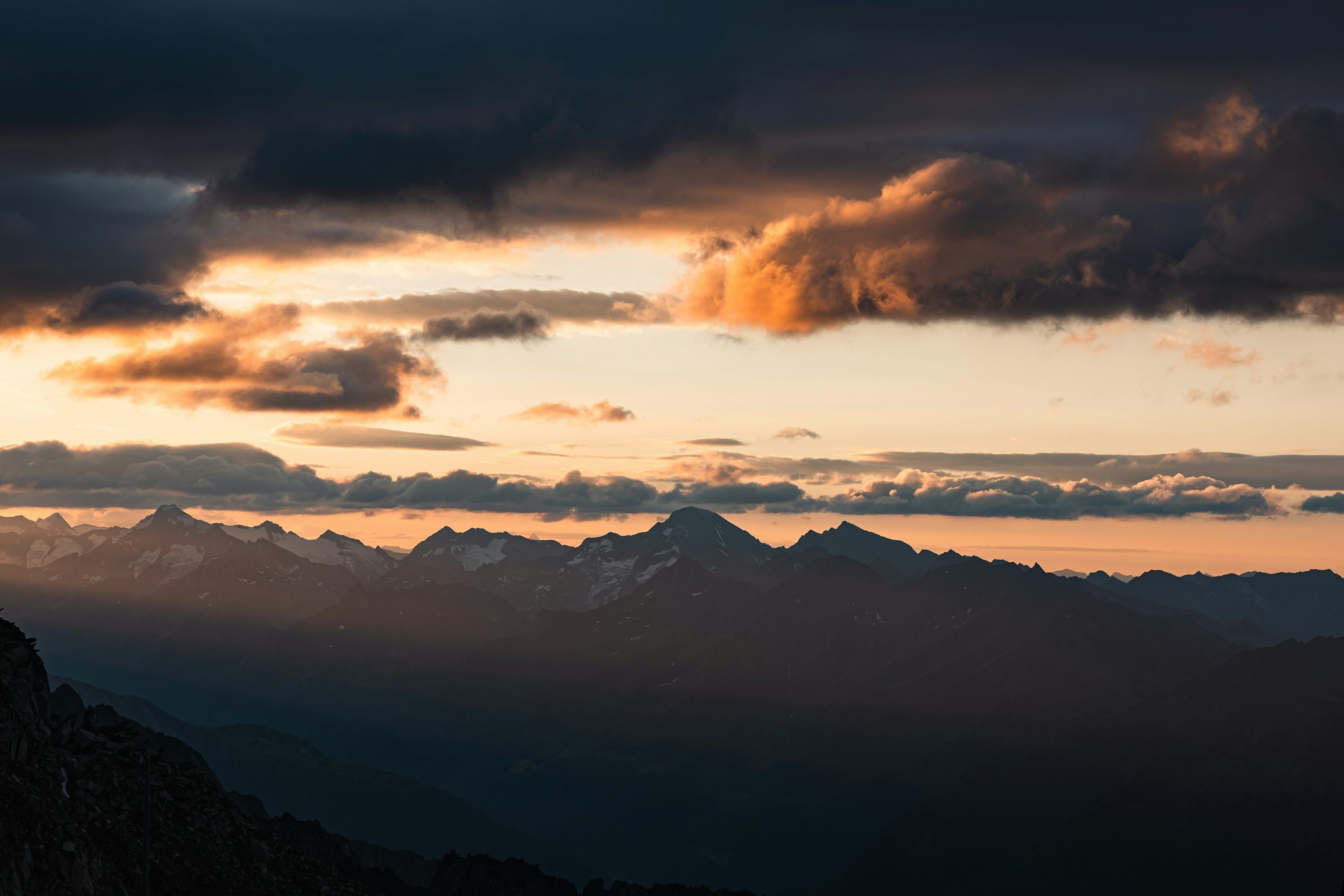 3000x2000 Majestic mountains silhouetted against a dramatic sunset sky. photo