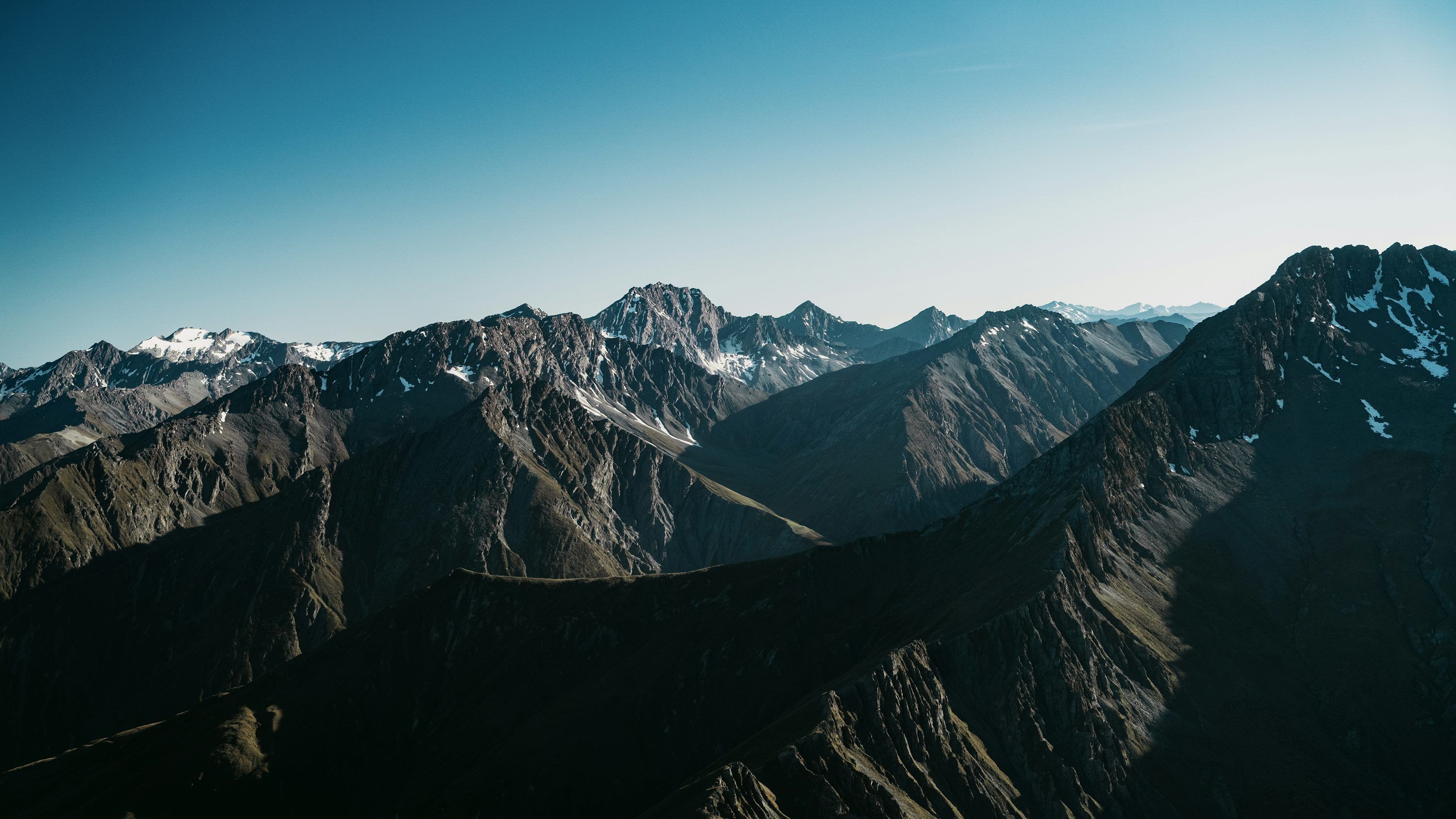 3000x1689 Majestic mountains stand tall under a bright sky. photo