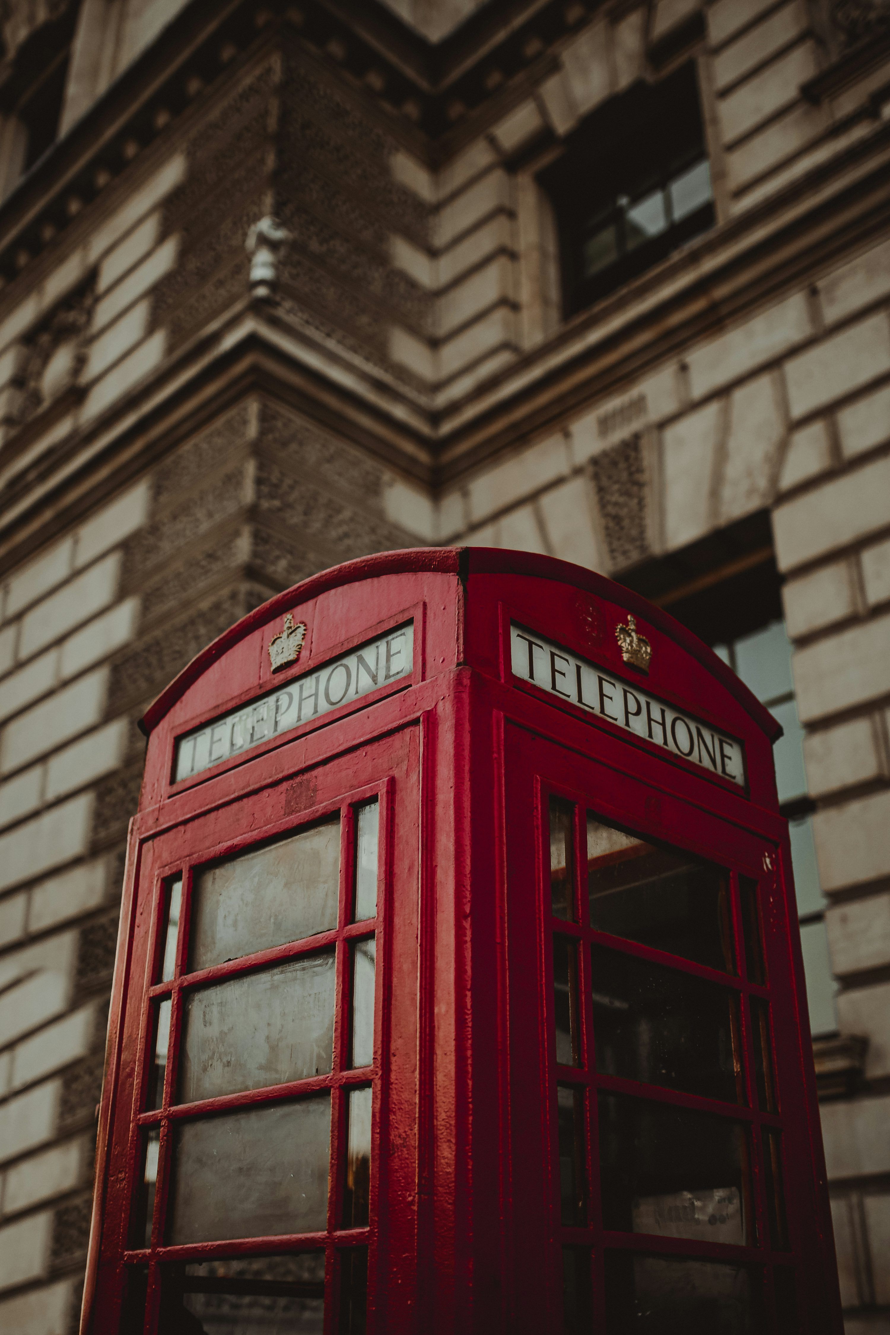 3000x4500 A couple of red phone booths sitting next to each other photo