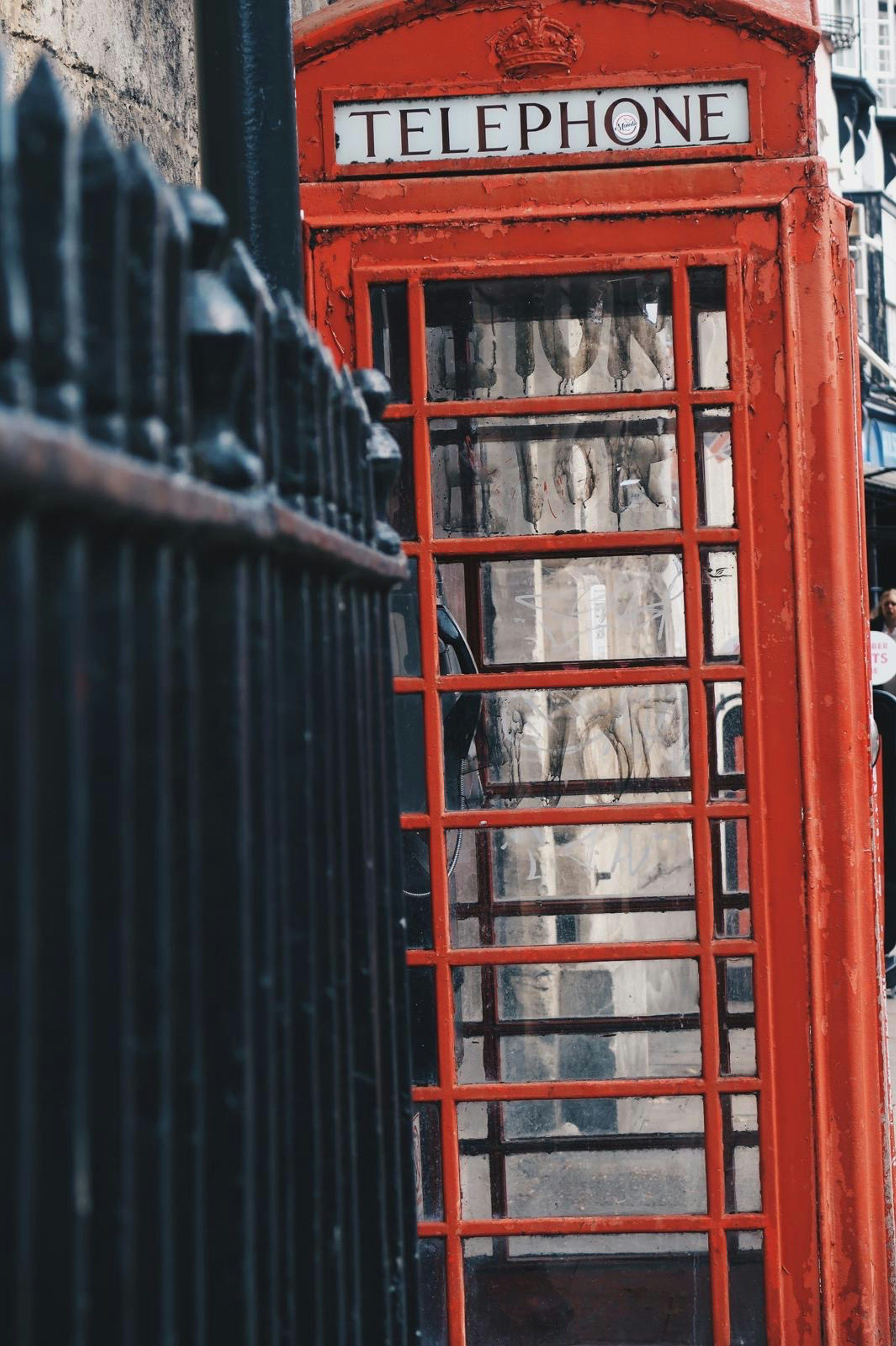 3000x4503 A couple of red phone booths sitting next to each other photo