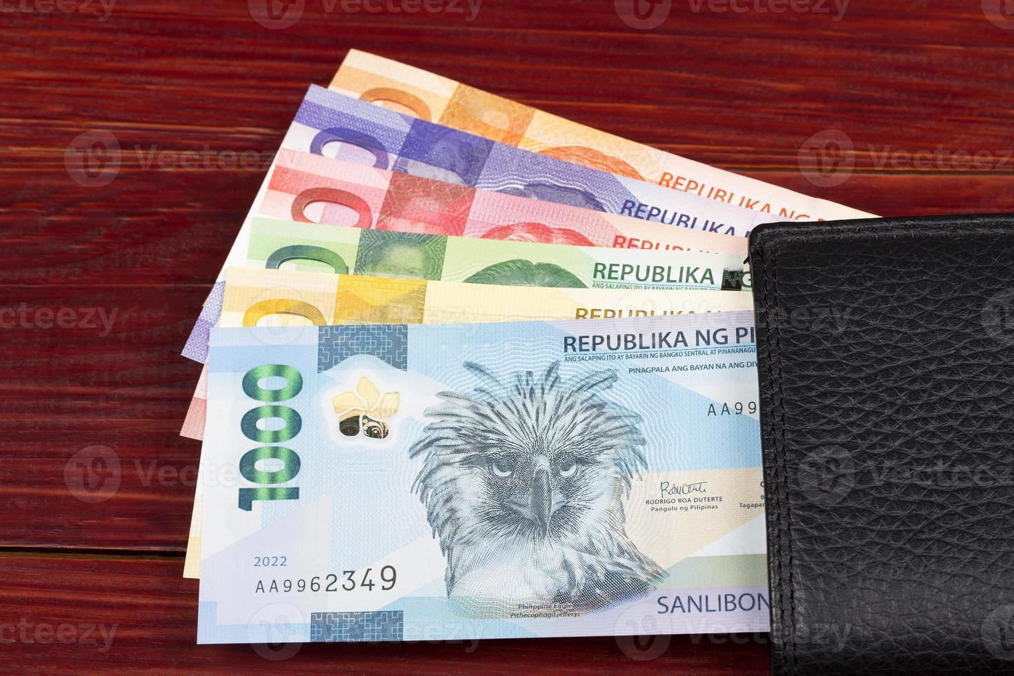 1470x980 Philippine money in the hand on a gray background
