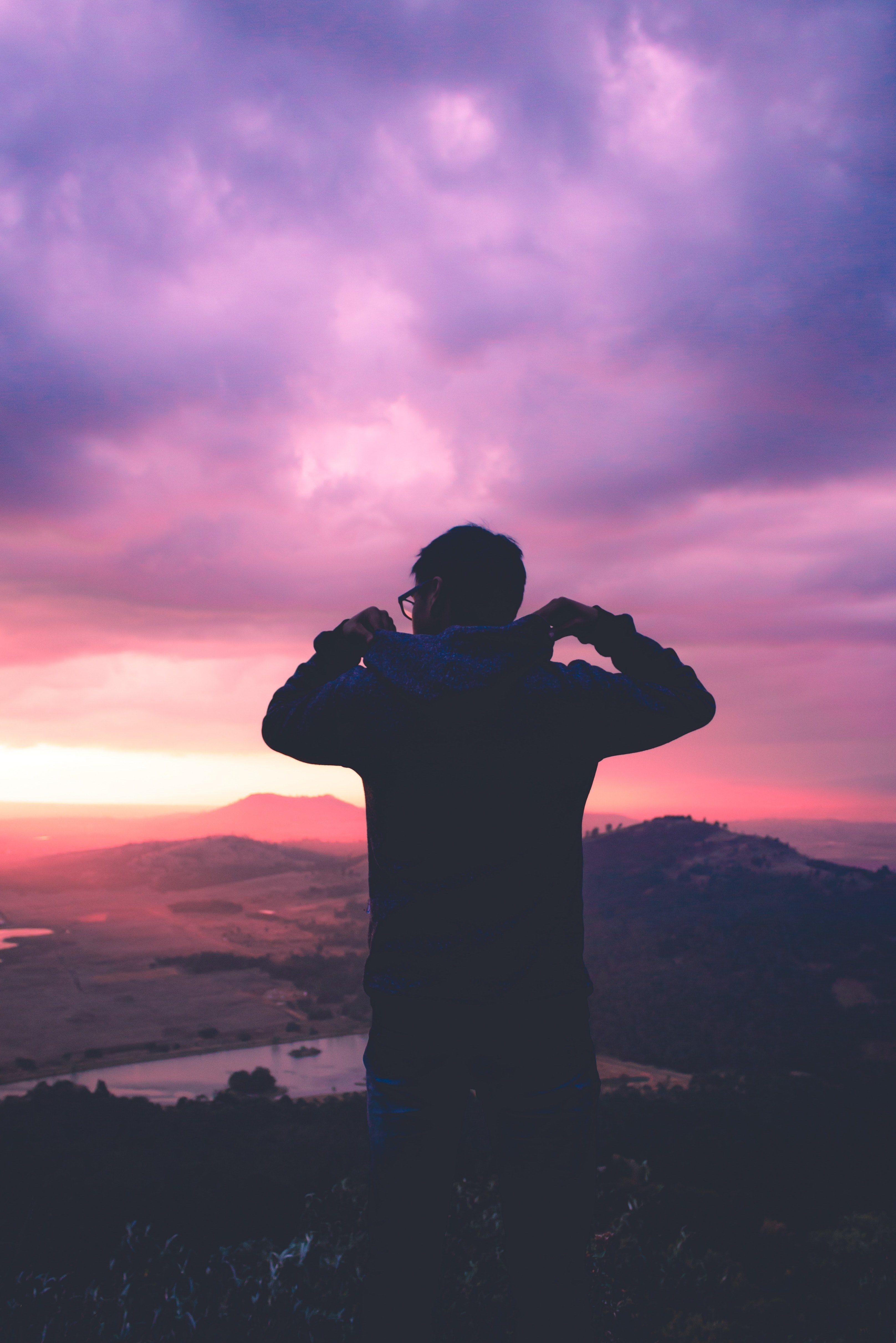 3233x4849 Wallpaper / a silhouette of a man looking out at a pink sunset and purple cloudy sky in toluca mexico, in the highest_ 4k wallpaper