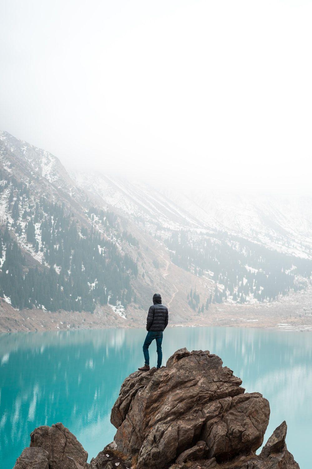 1000x1500 person standing on rock formation photo