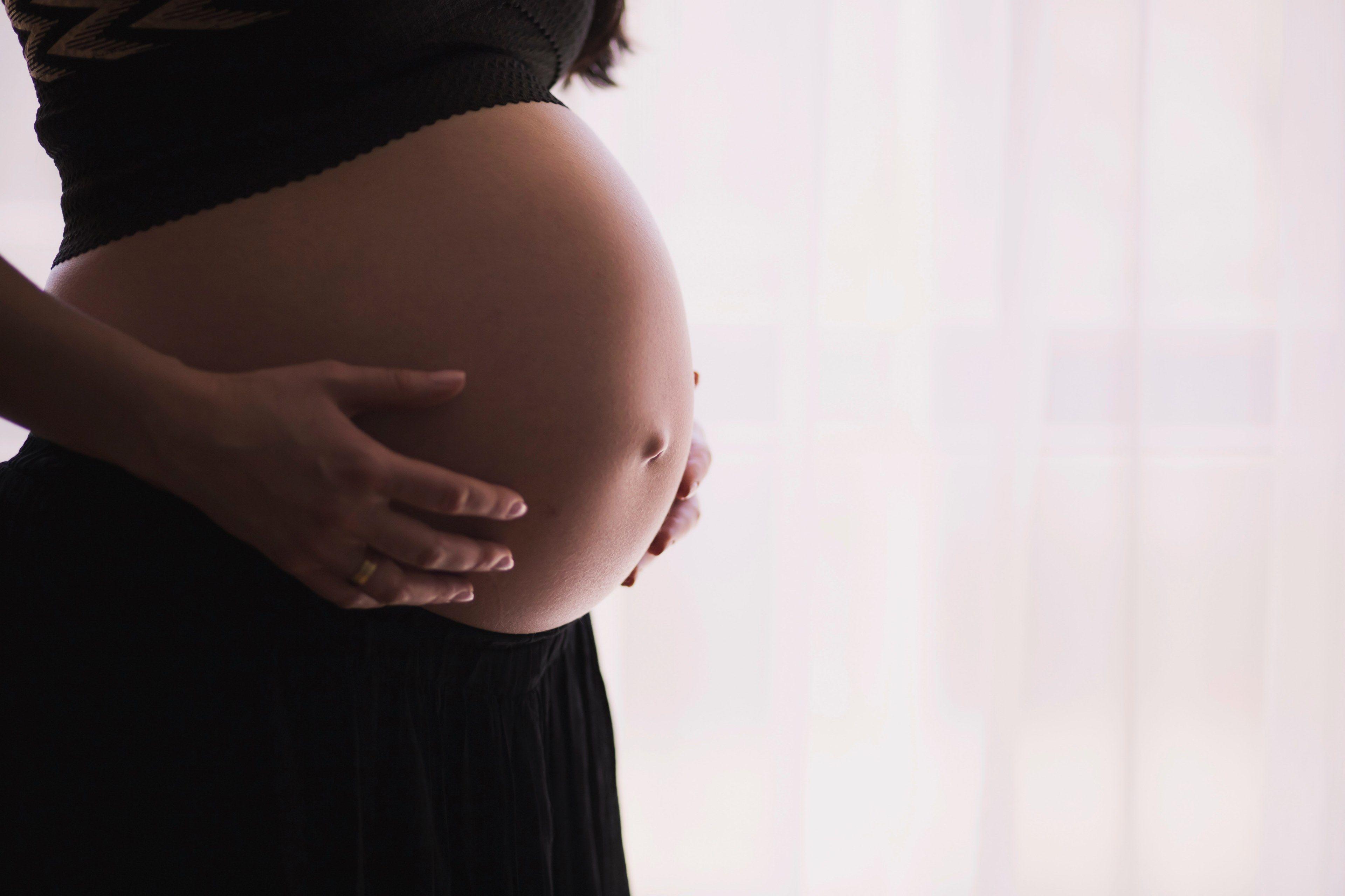 3840x2560 Wallpaper / pregnant woman in black holds her exposed stomach expectantly, expecting 4k wallpaper