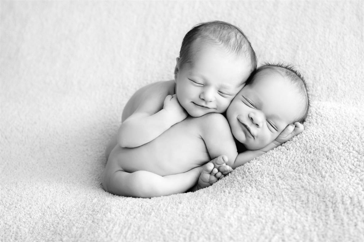 Premium Photo  Tiny newborn twin boys in white bodysuits on a white  background in white caps newborn twins sleep next to their brother on the  background of the heart two newborn