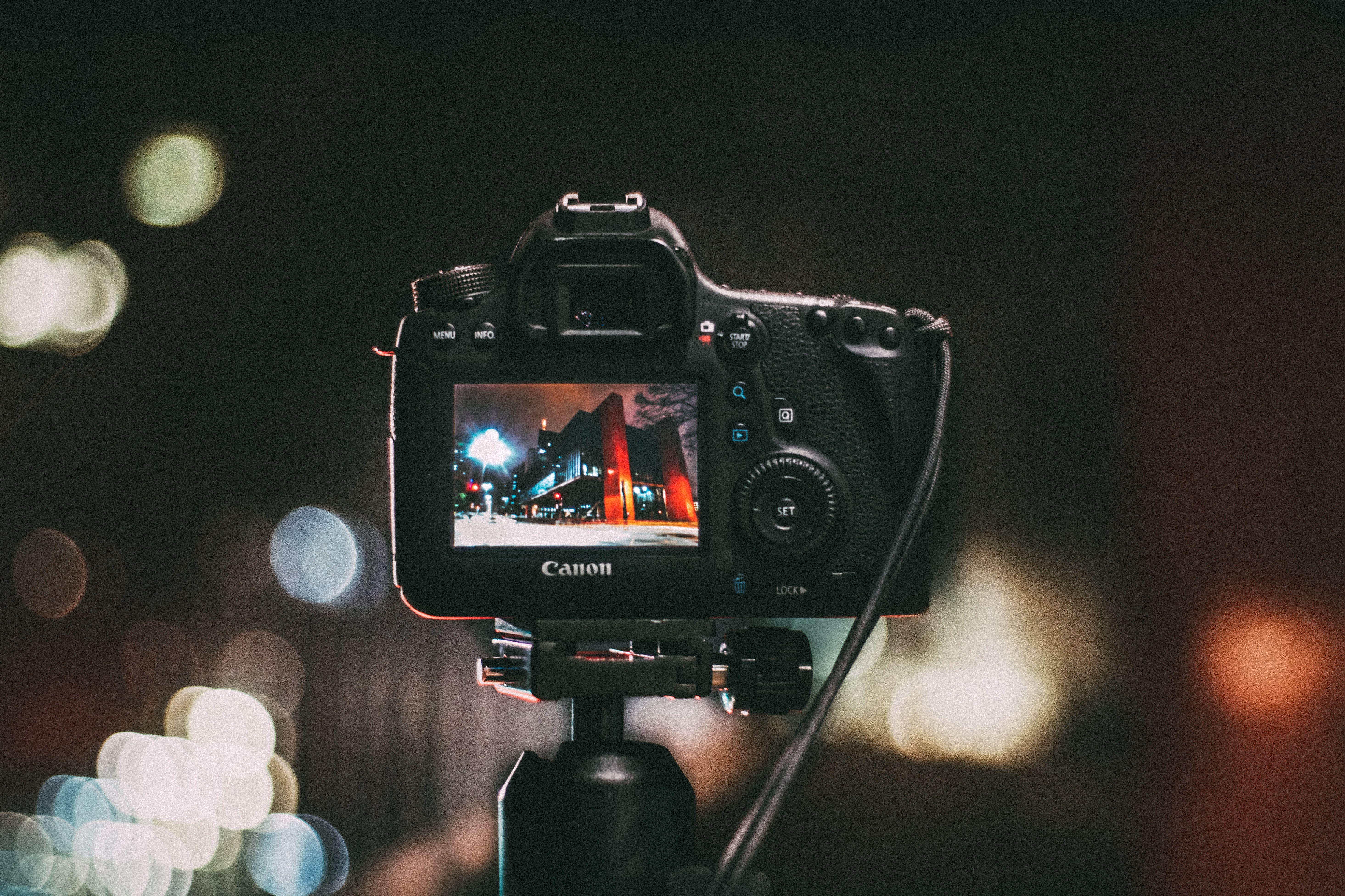 5859x3906 Selective Focus Photography of Black Canon Camera Displaying Photo of Red and Black Building · Free
