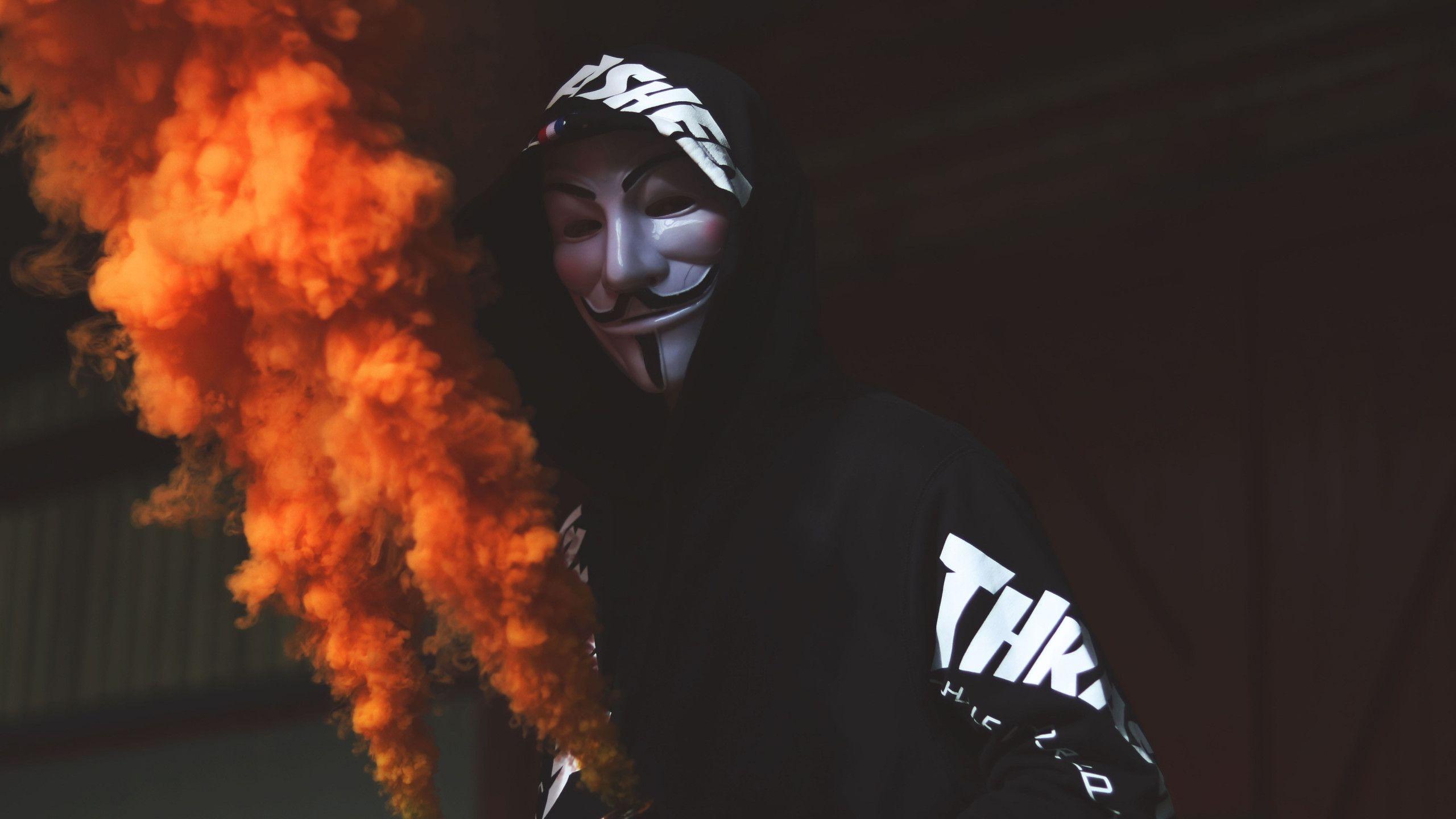 2560x1440 Download wallpaper: Anonymous mask and orange smoke 2560x1440