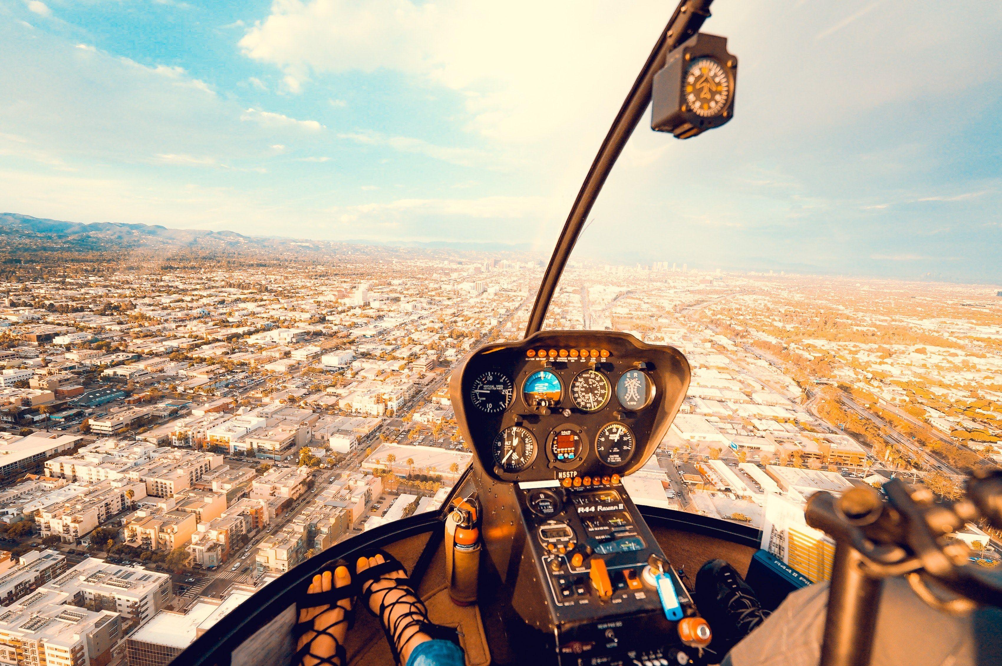3400x2261 Wallpaper / inside the cockpit of a helicopter flying above a busy city downtown, flying above the city 4k wallpaper