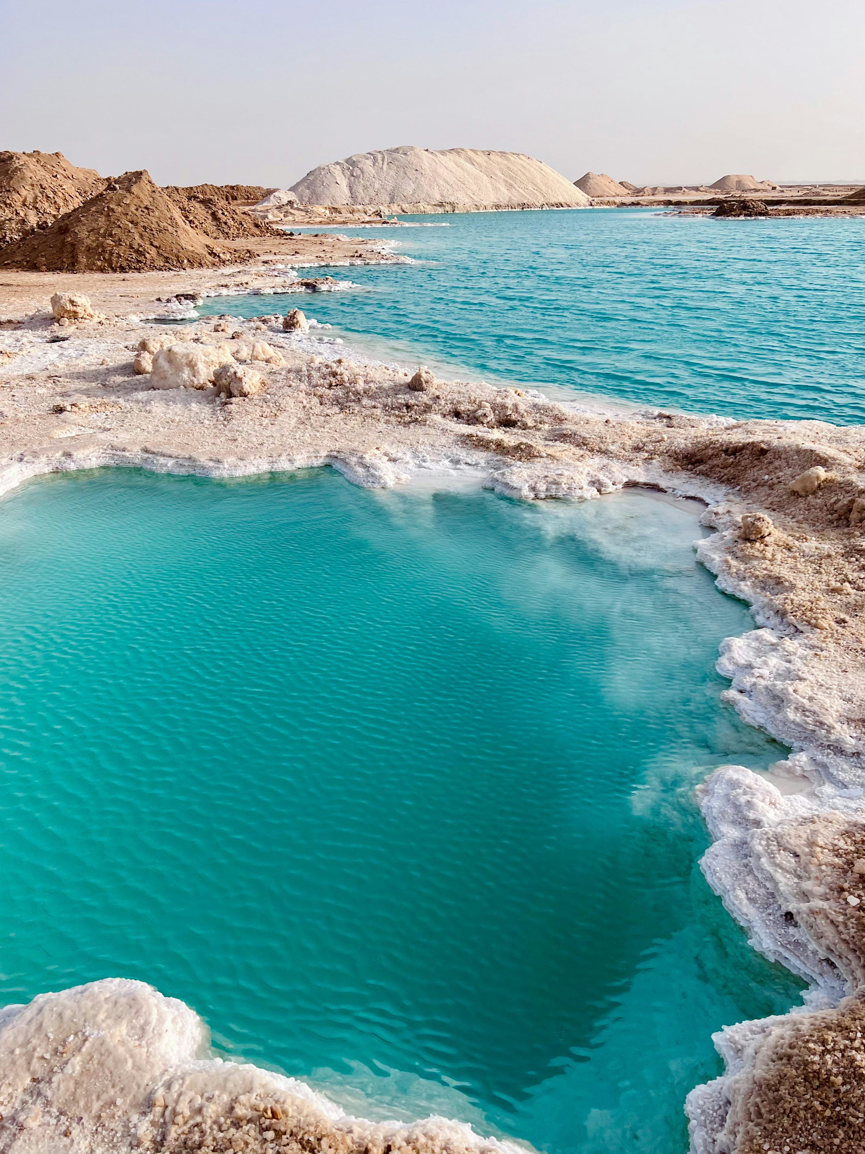 3000x4000 A body of water with rocks and a beach in the background photo