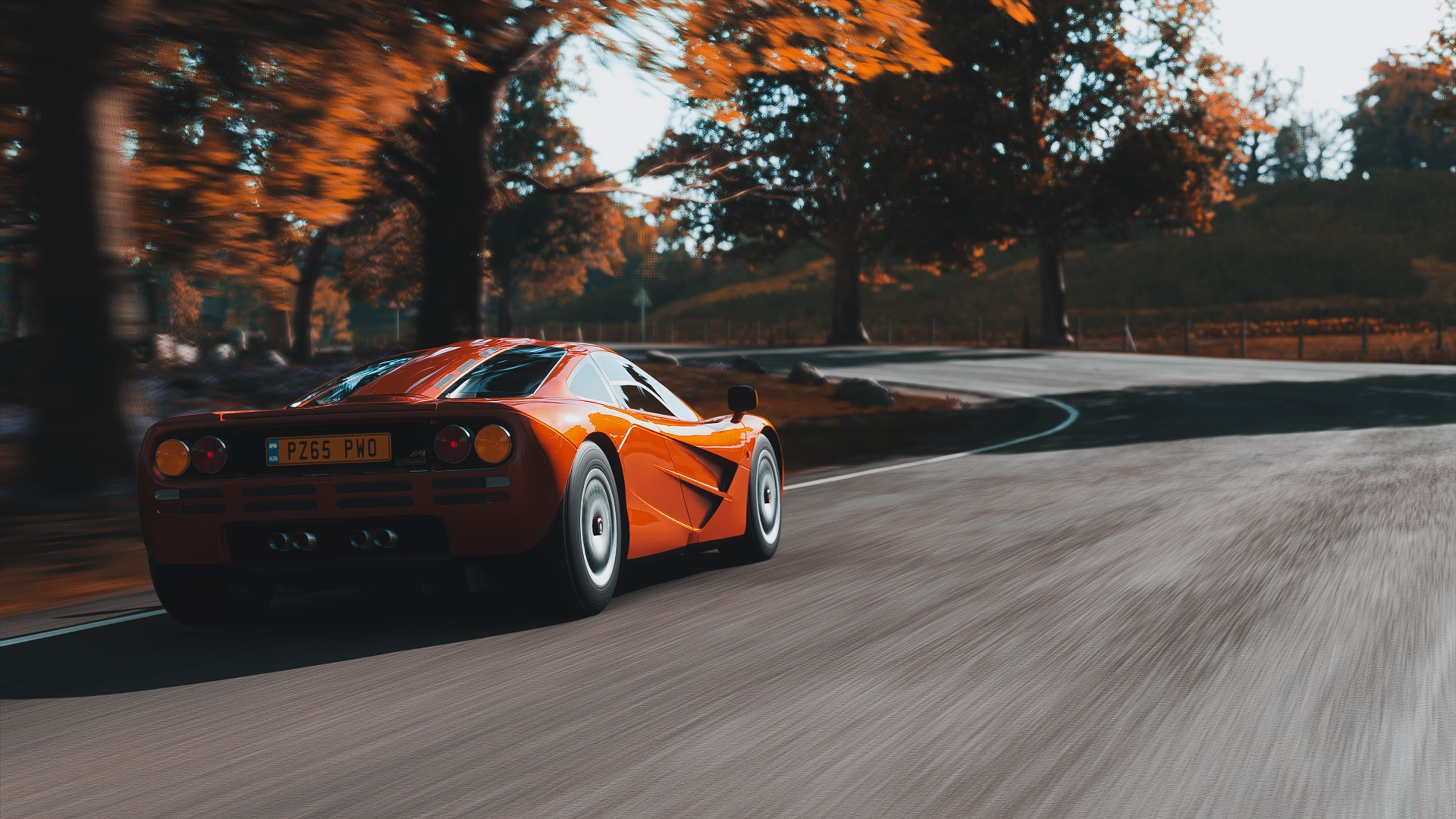 3265x1837 A Fast Moving McLaren F1 LM on the Road · Free