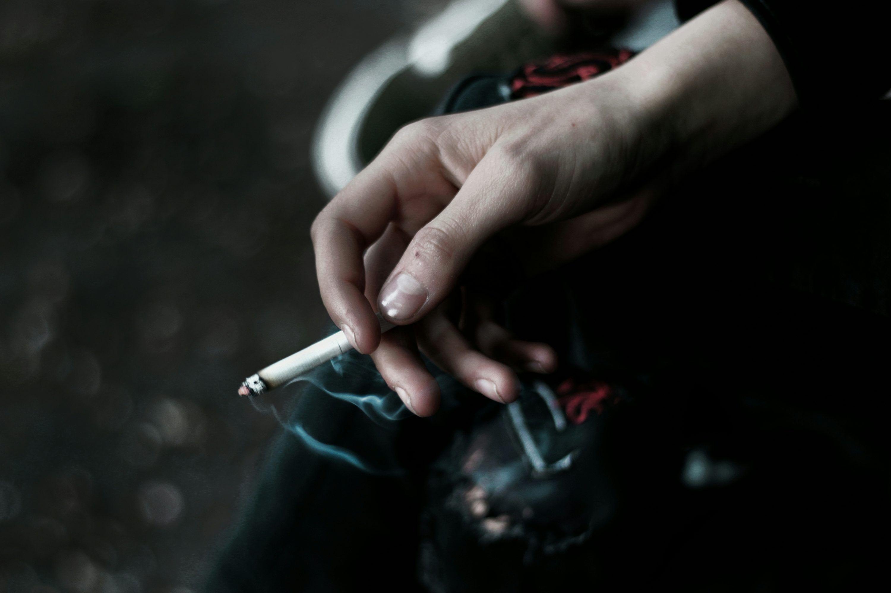 3000x1999 A person holding a cigarette in their hand photo