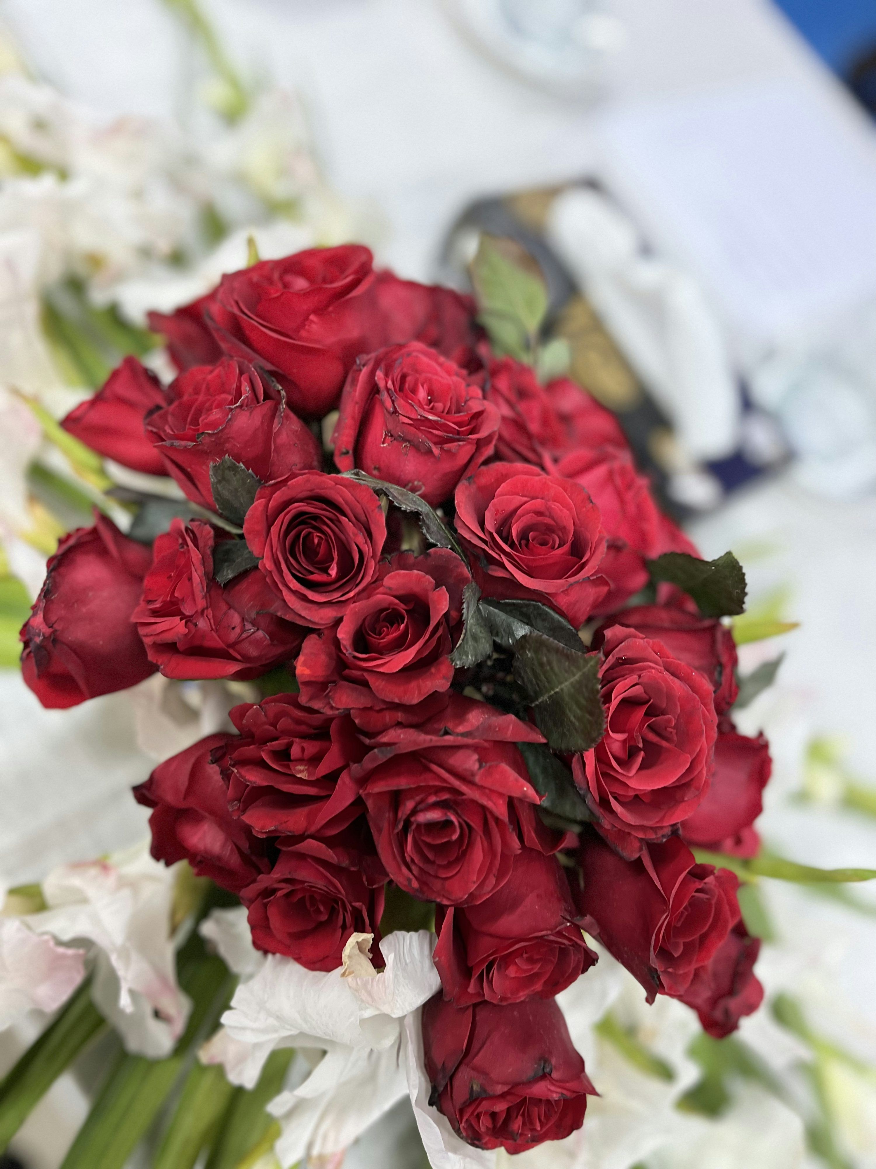 3000x4000 A bouquet of red roses sitting on top of a table photo