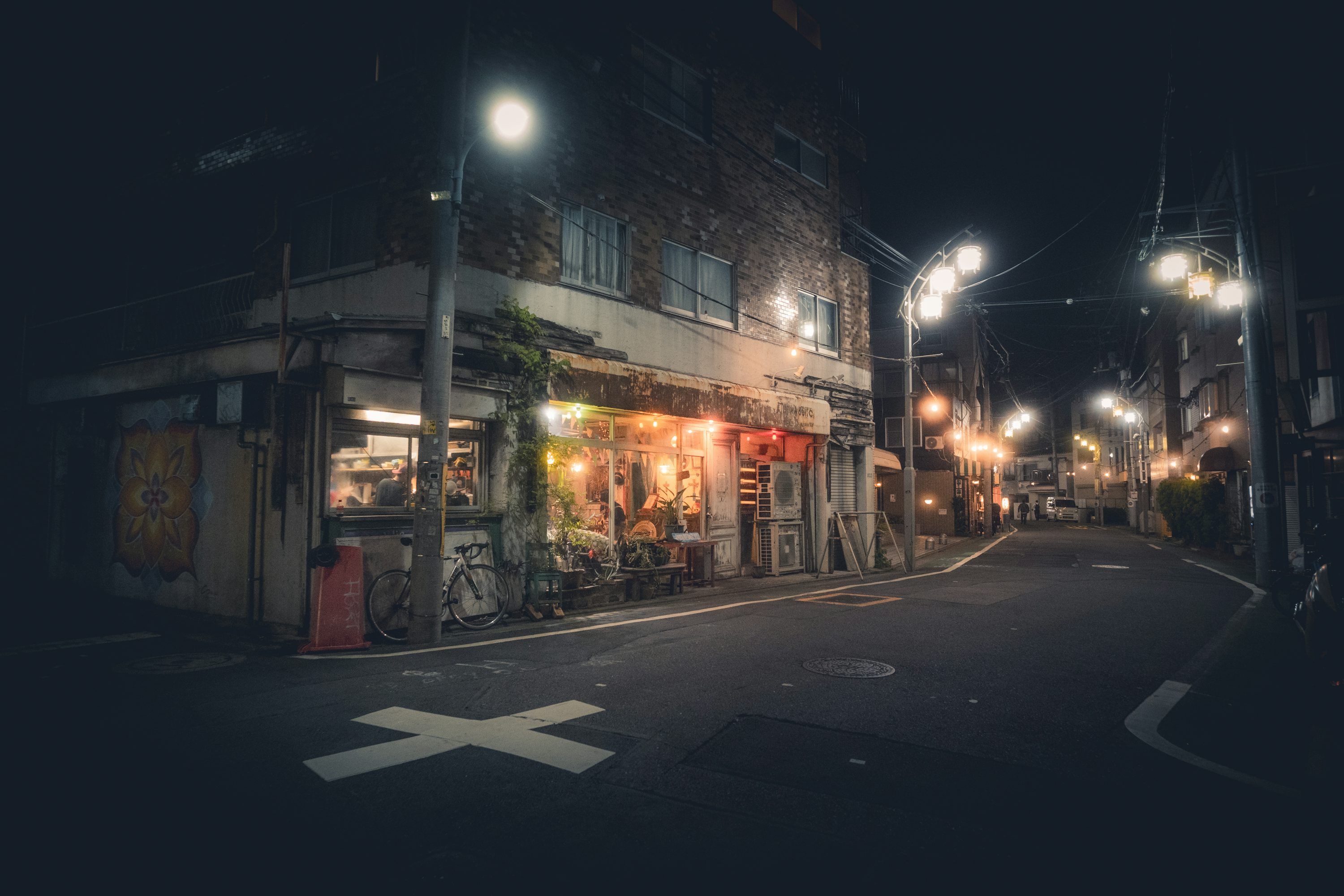 3000x2000 Dark street corner with glowing shop lights at night. photo