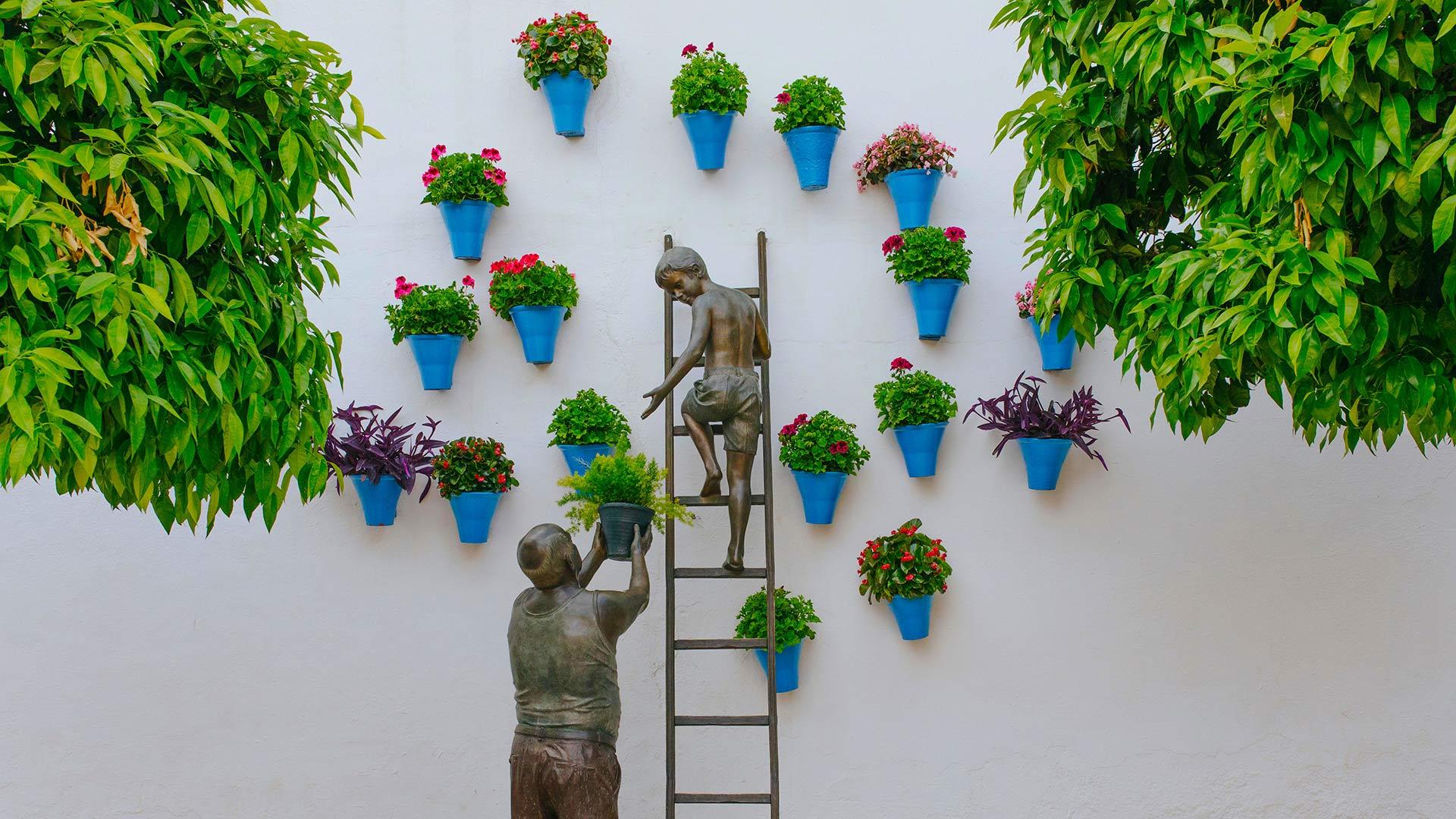 1920x1080 Bronze sculpture of a child and his grandfather caring for plants and flowers in the San Basilio neighborhood of Córdoba, Spain