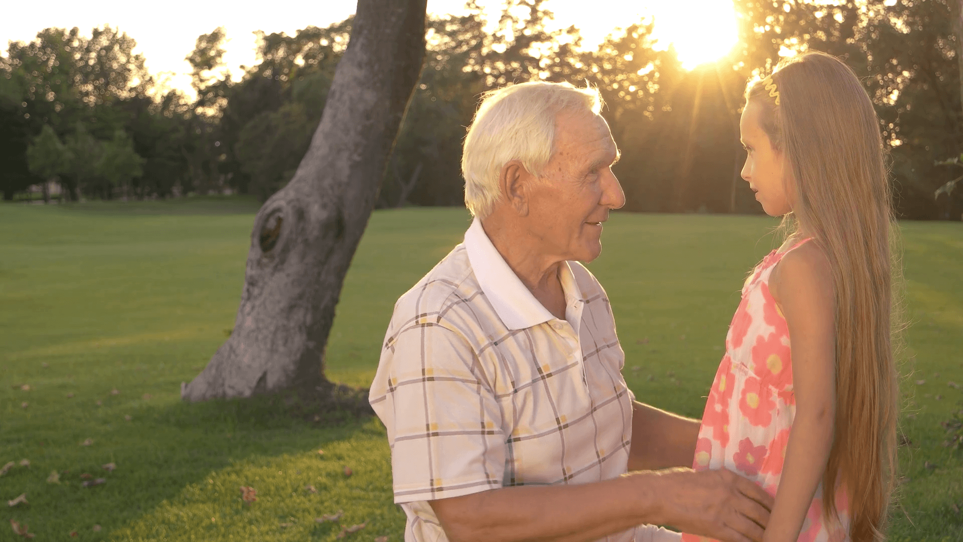 1920x1080 Grandfather and granddaughter outdoors. Grandpa comforting little girl and talking to her in park. Taking care of grandchilds. Stock Video Footage