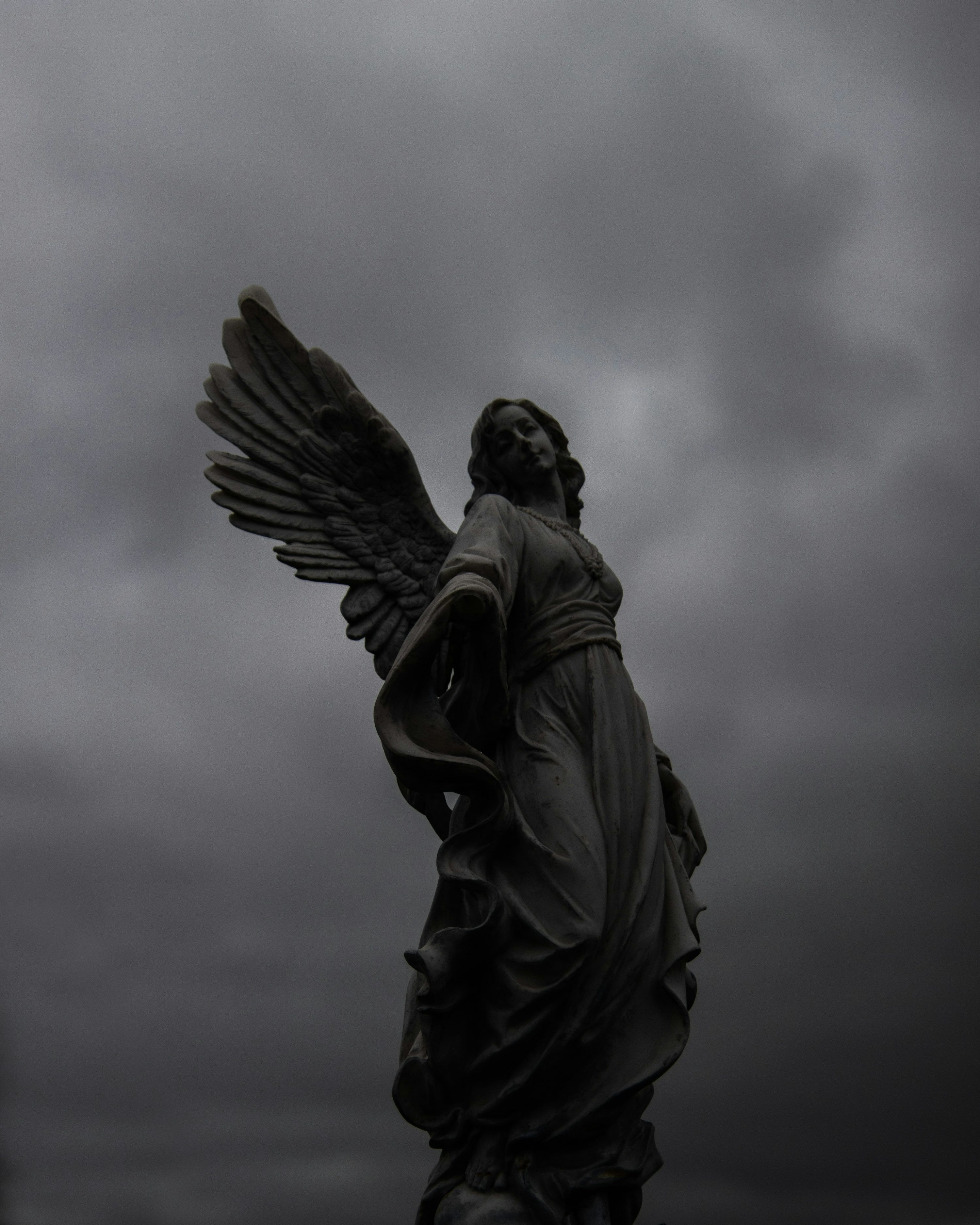 3000x3750 A statue of an angel on a cloudy day photo