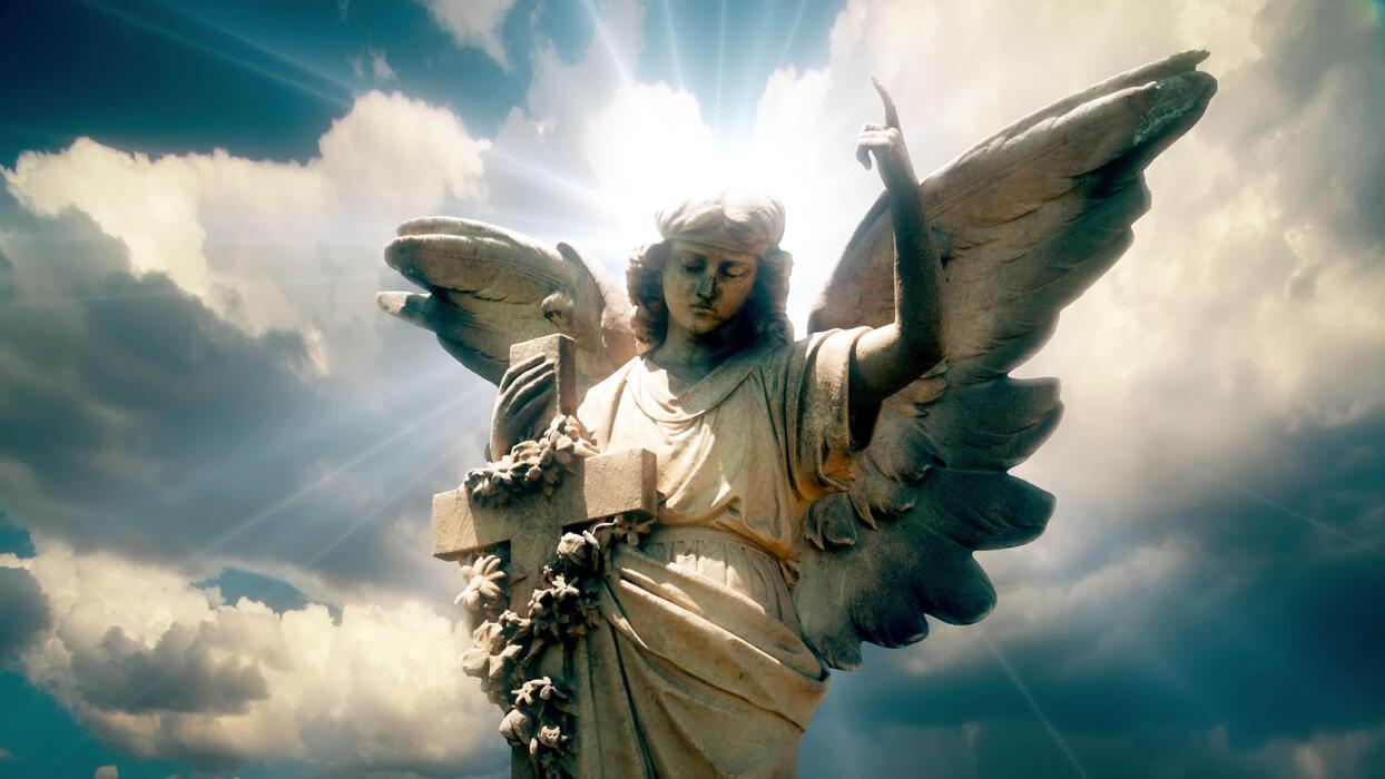 1244x700 The statue of an Angel on time lapse clouds
