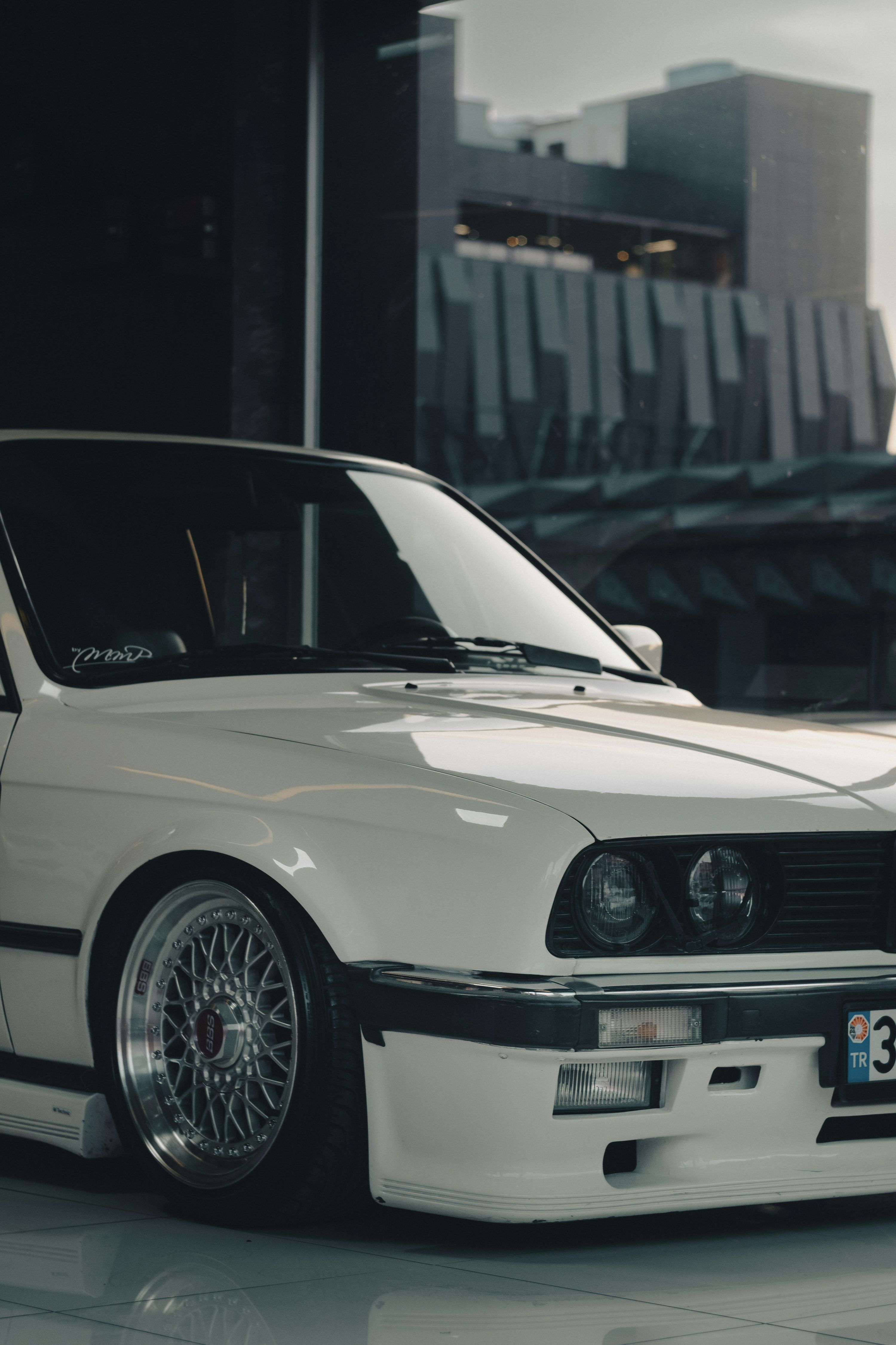 3000x4500 A white car parked in front of a building photo