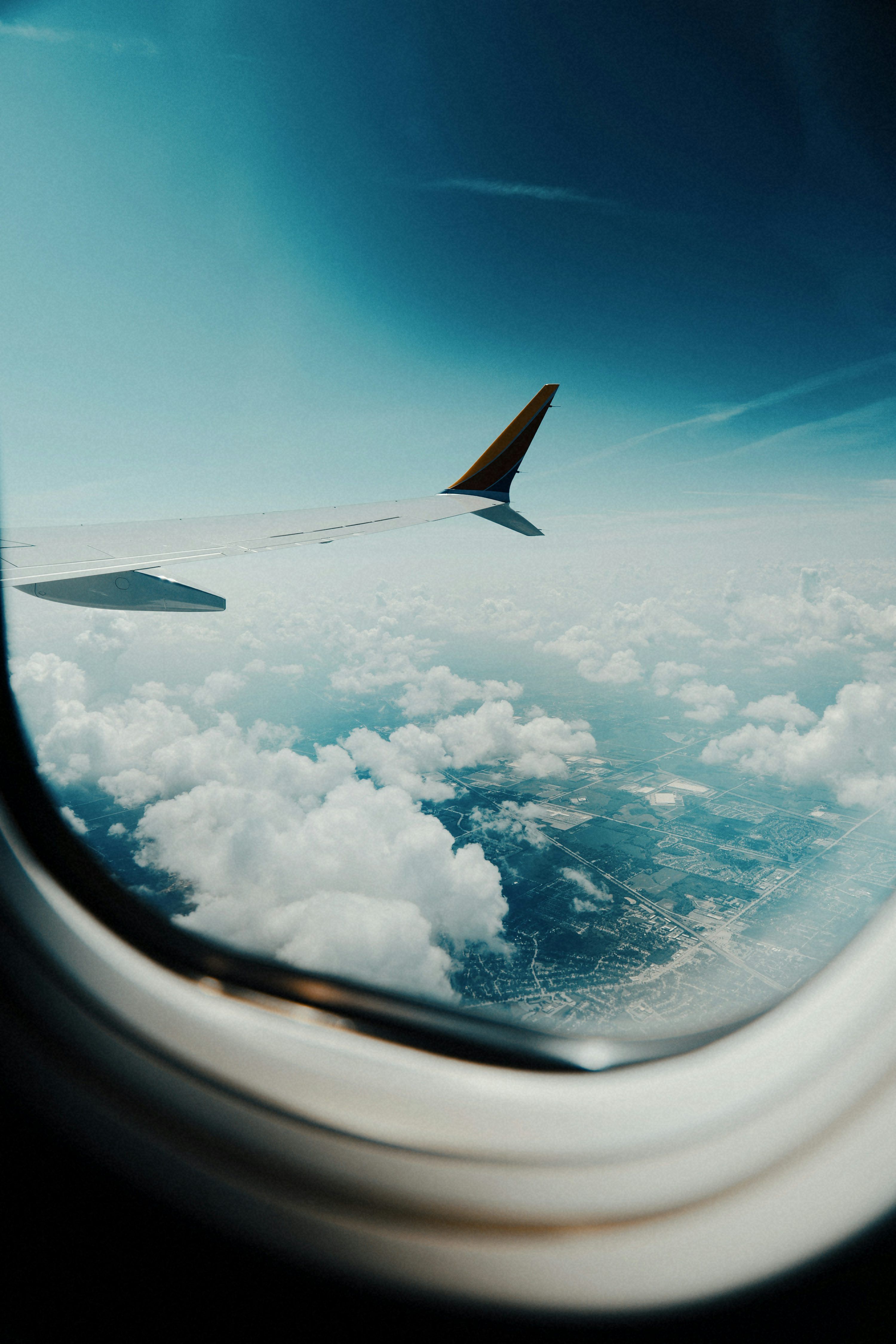 3000x4499 Airplane wing over clouds and landscape from window photo