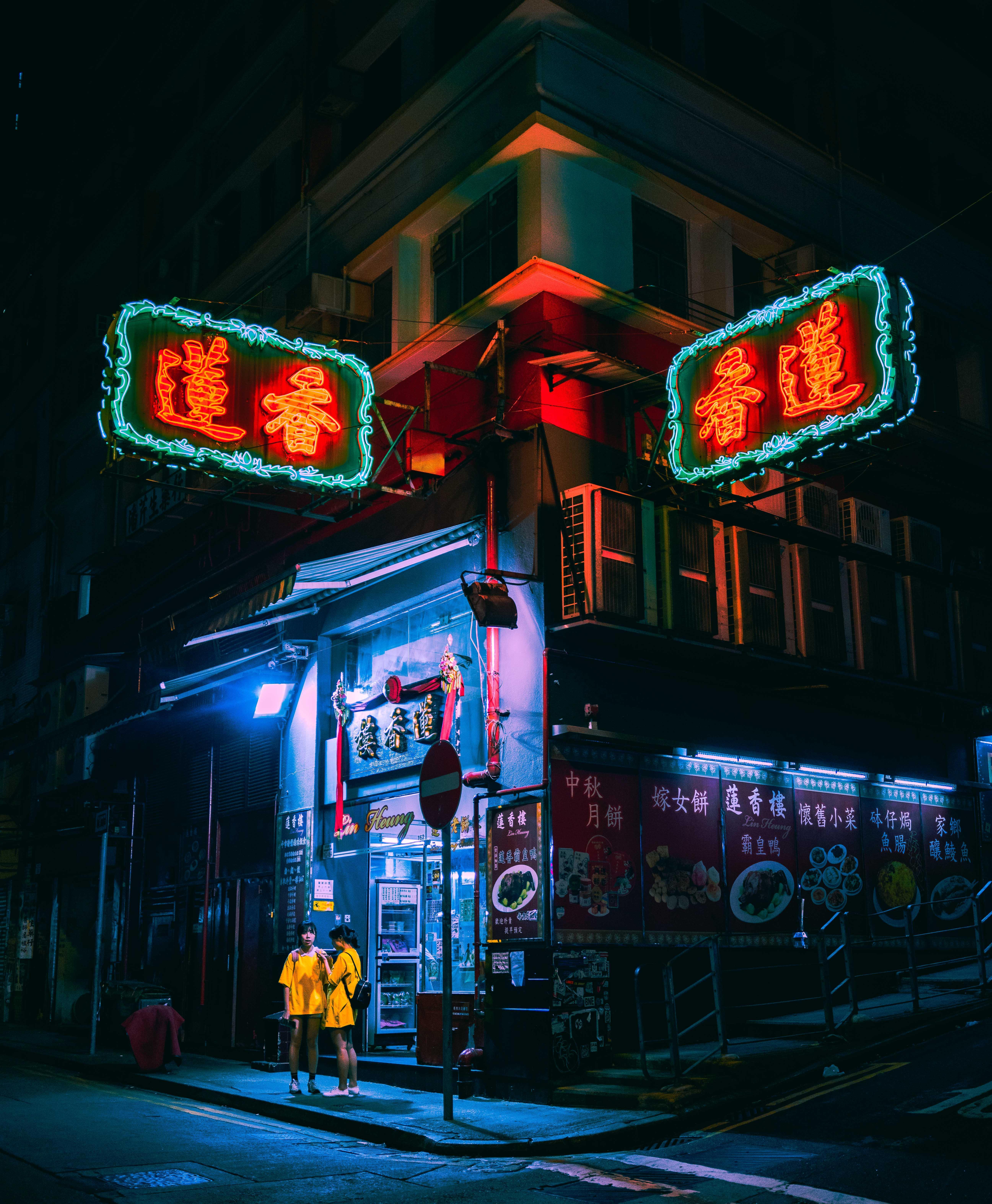 5187x6298 ITAP of two girls under the neon lights of Hong Kong