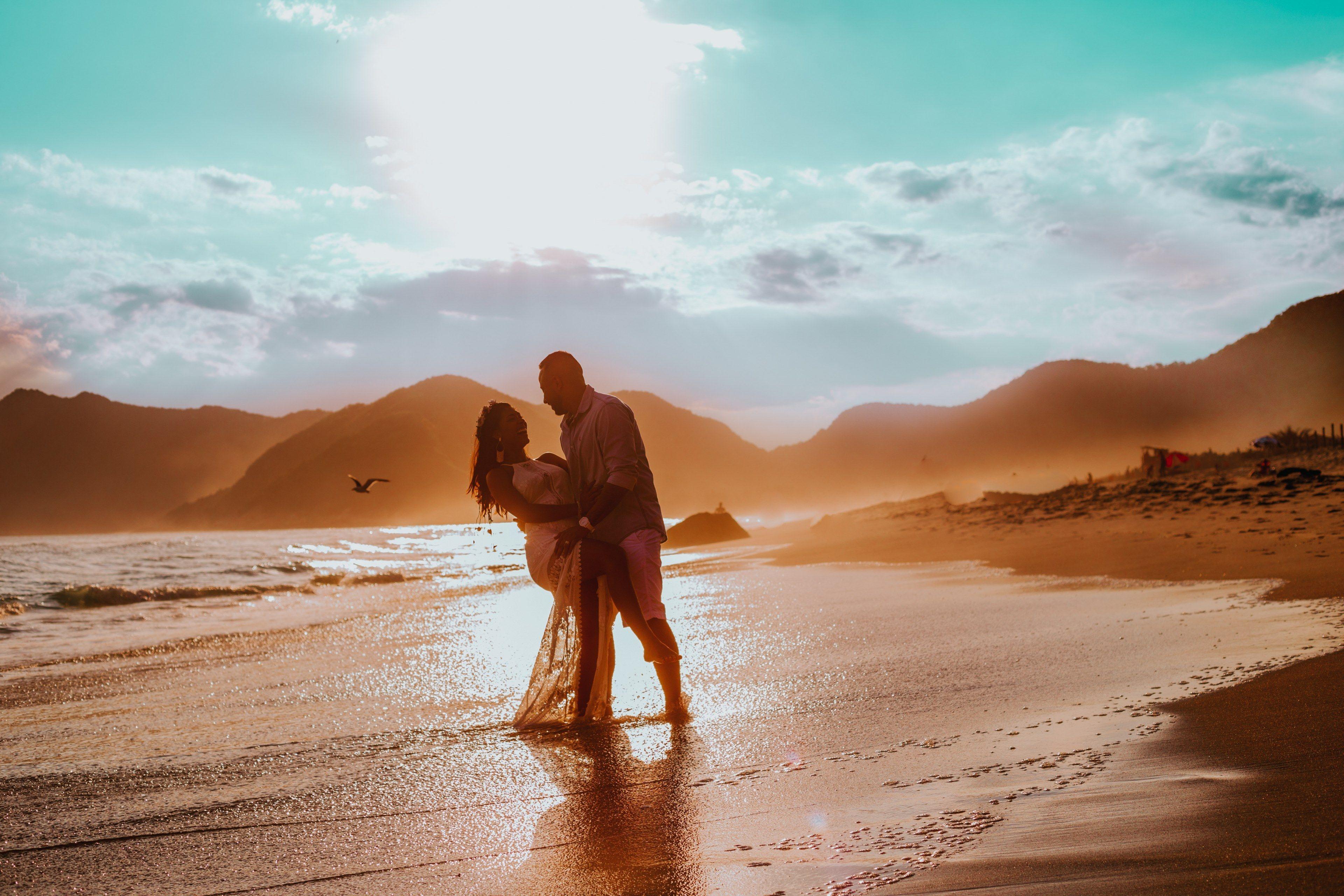 3840x2560 Wallpaper / happy romantic couple holding each other on a sand beach during sunset in praia de grumari, romantic couple on a beach 4k wallpaper