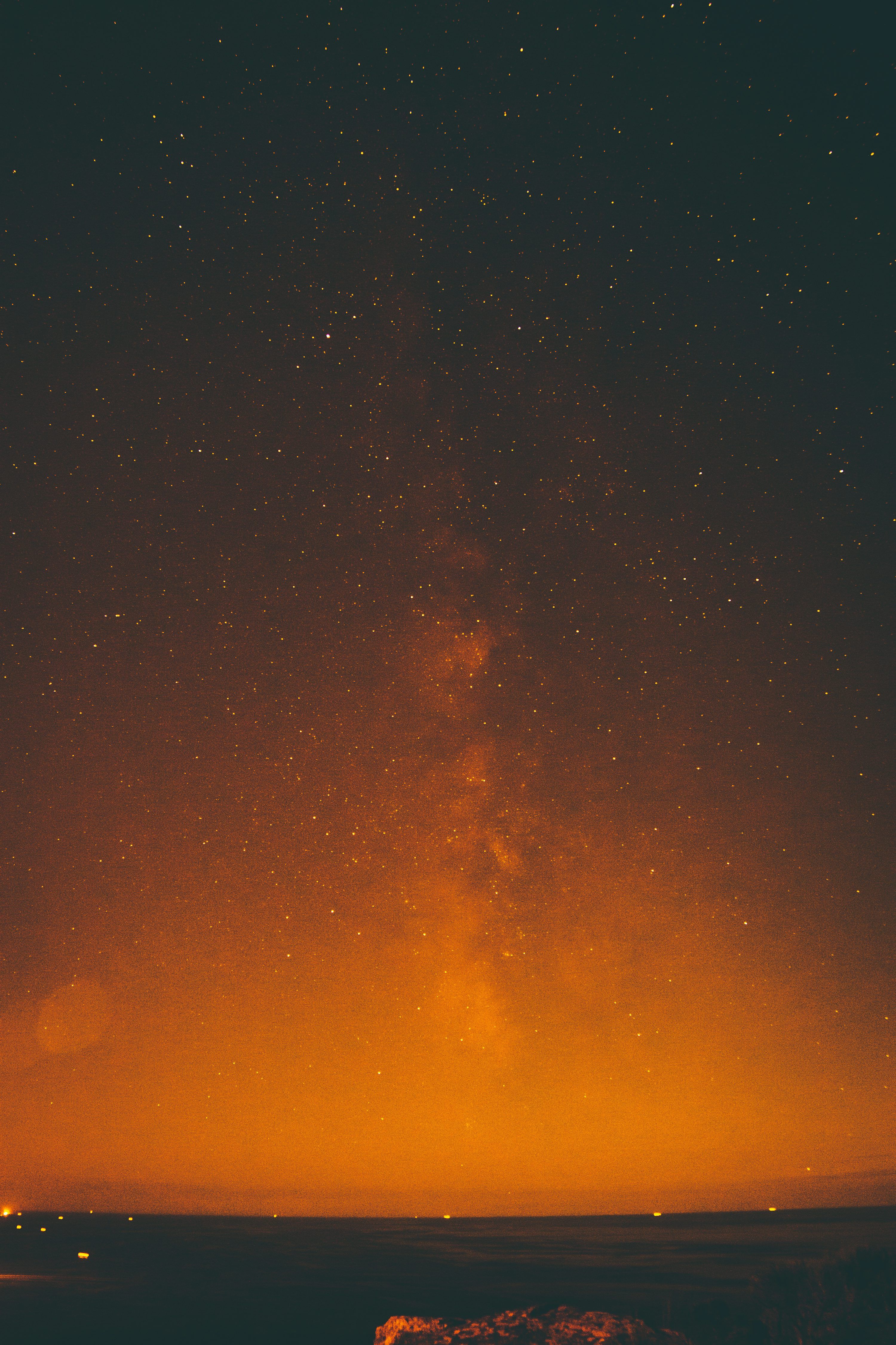 3000x4500 The night sky is filled with stars and a bright orange glow photo