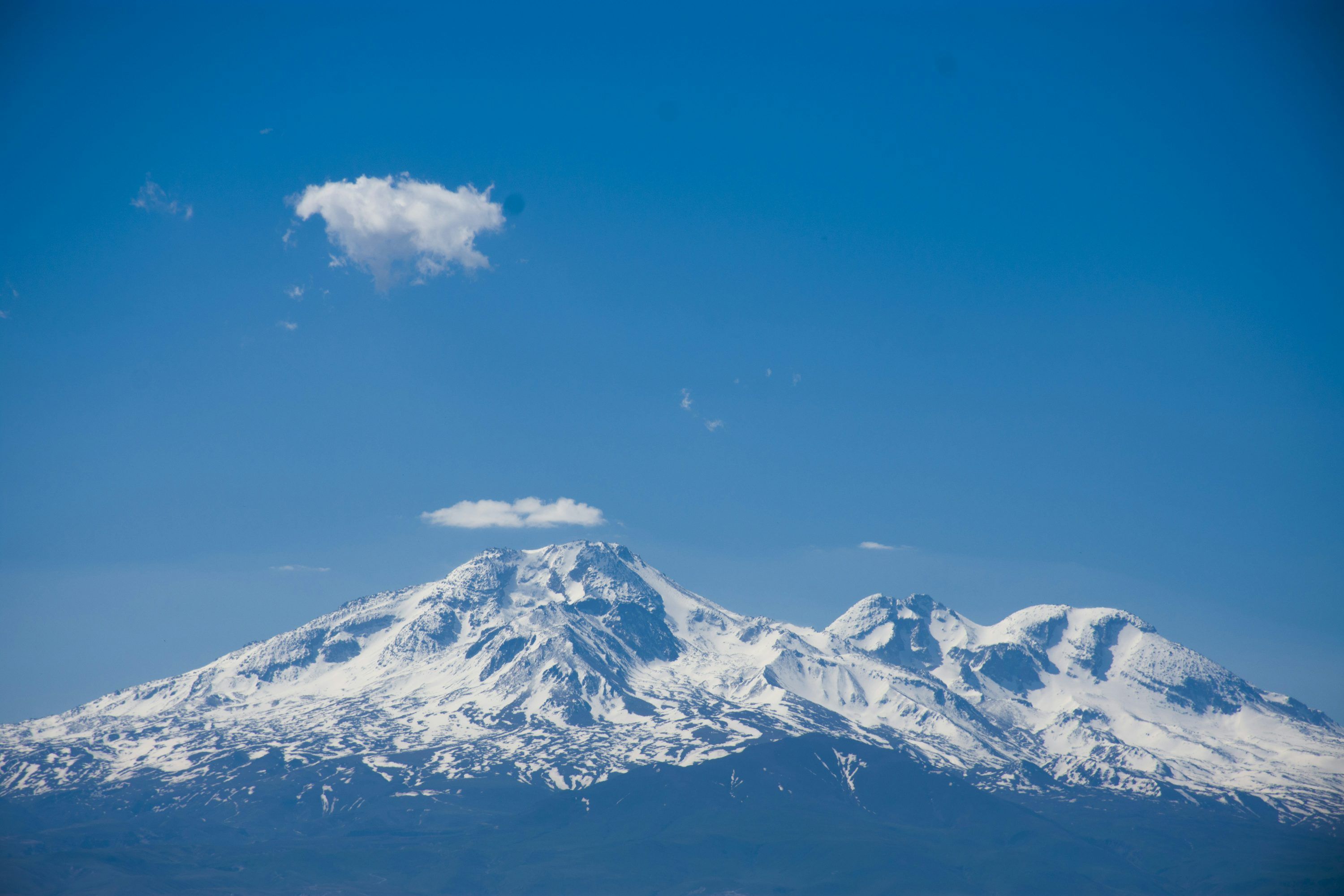 3000x2000 A large snow covered mountain under a blue sky photo