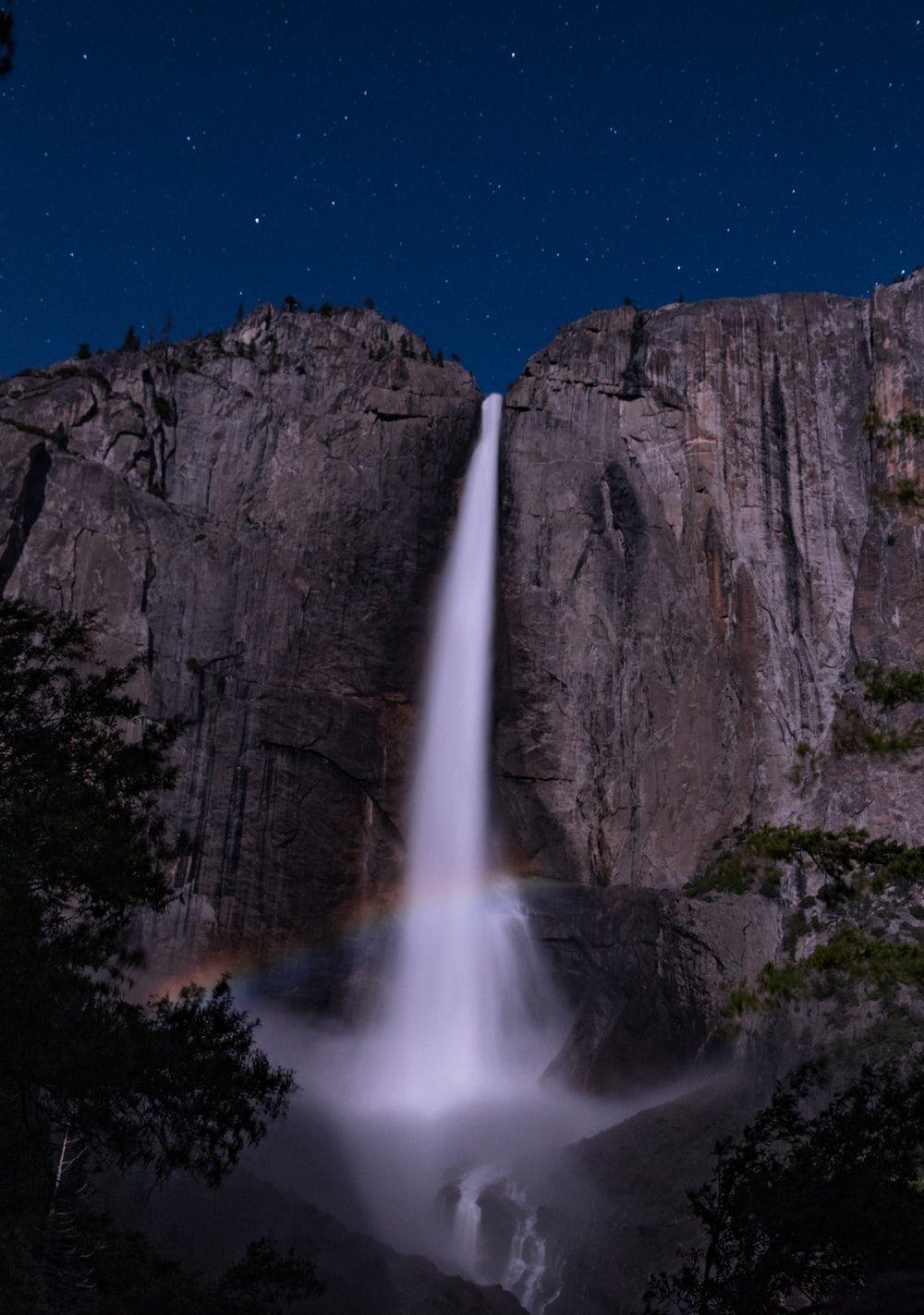 1000x1423 rainbow in front of waterfalls at night time photo